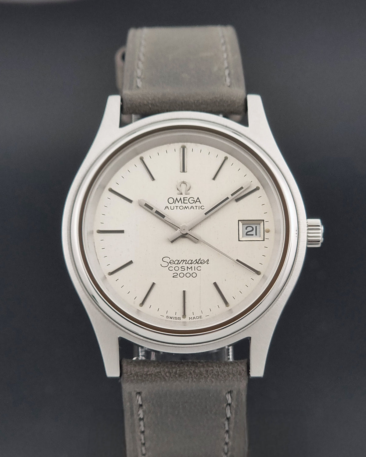 Vintage Omega Wristwatch 166.128 Seamaster Cosmic 2000 with a cream dial and stainless steel case on a dark background
