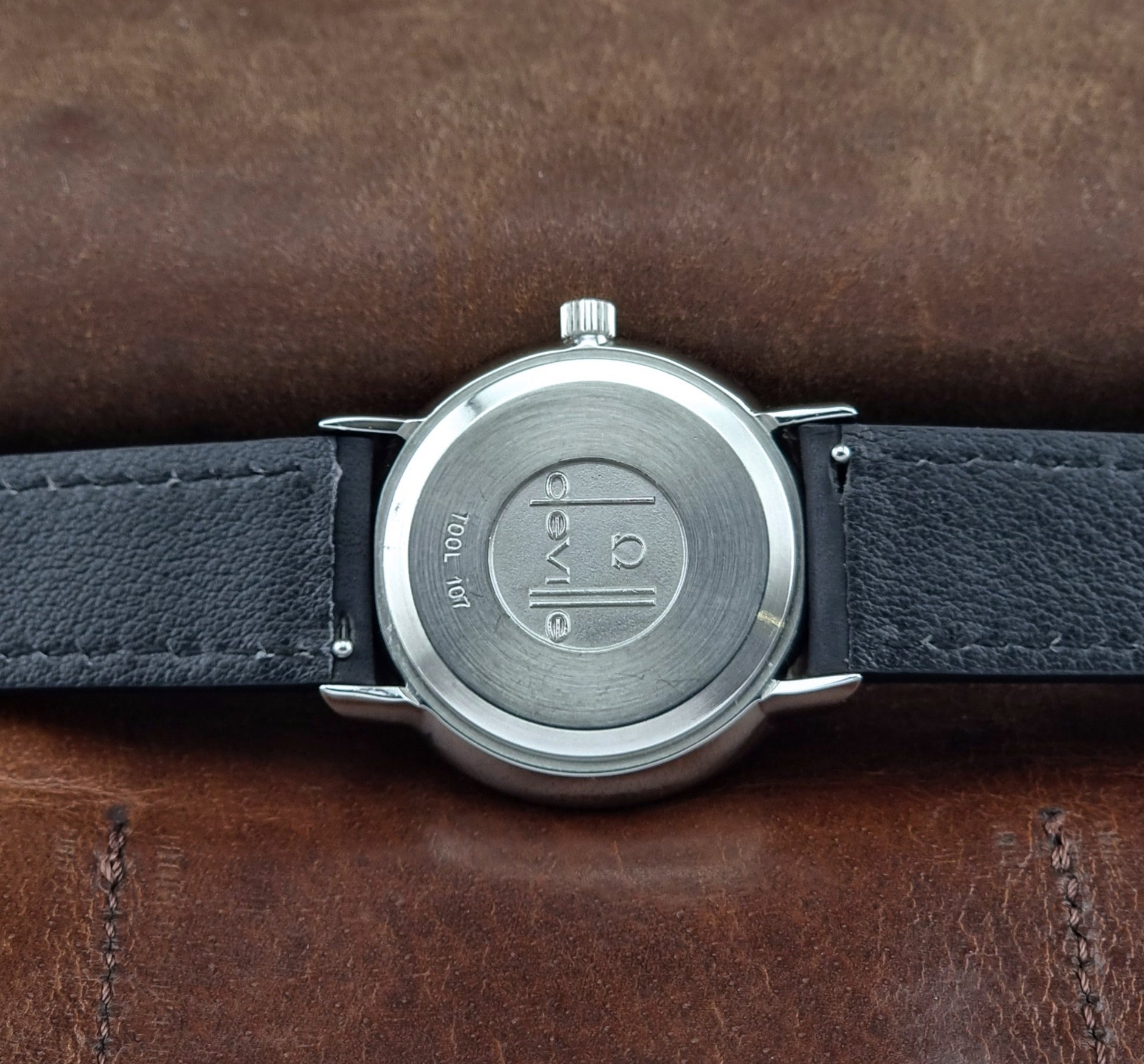 Vintage Omega de-ville wristwatch on a brown background case back view