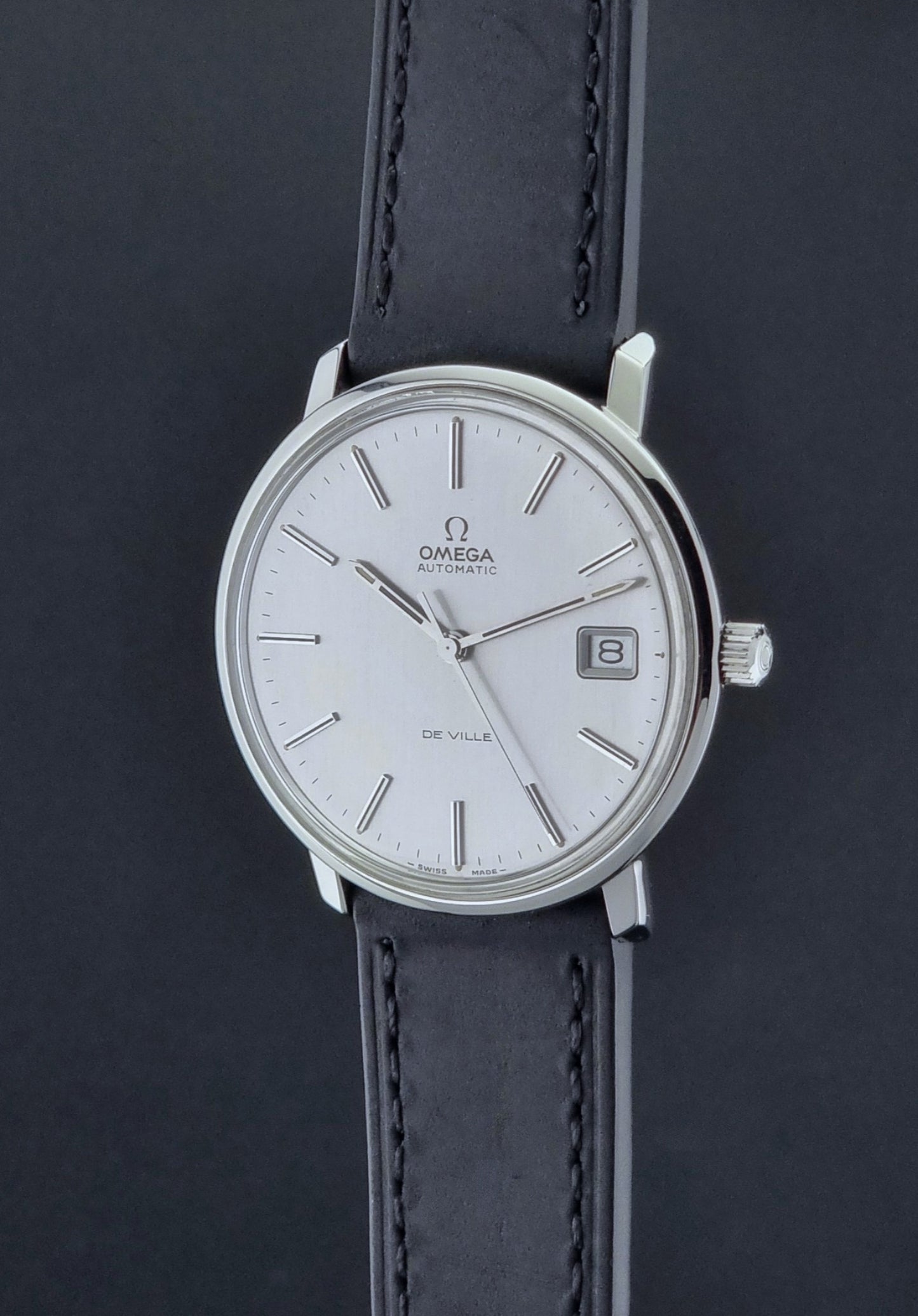 Vintage Omega de-ville wristwatch on a dark background crown profile