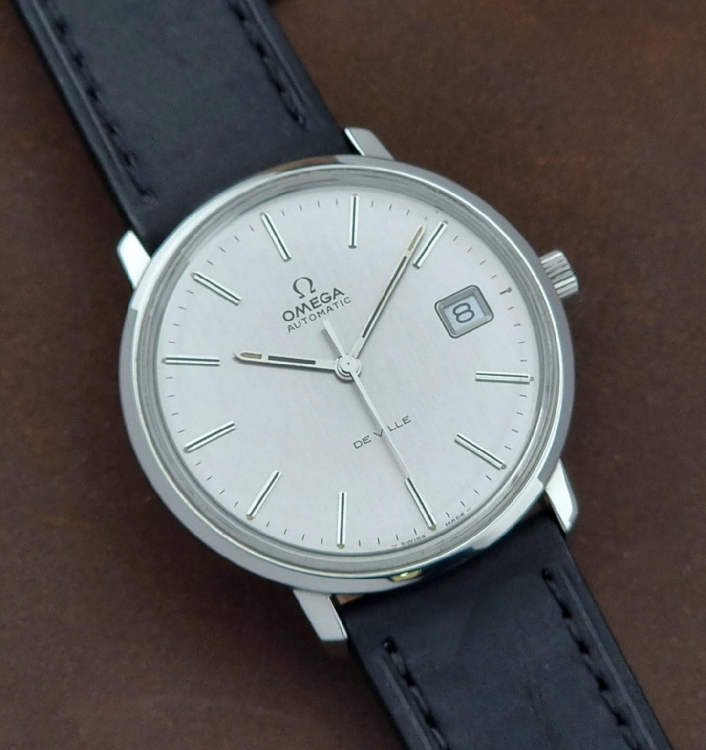 Vintage Omega de-ville wristwatch on a brown background close dial view