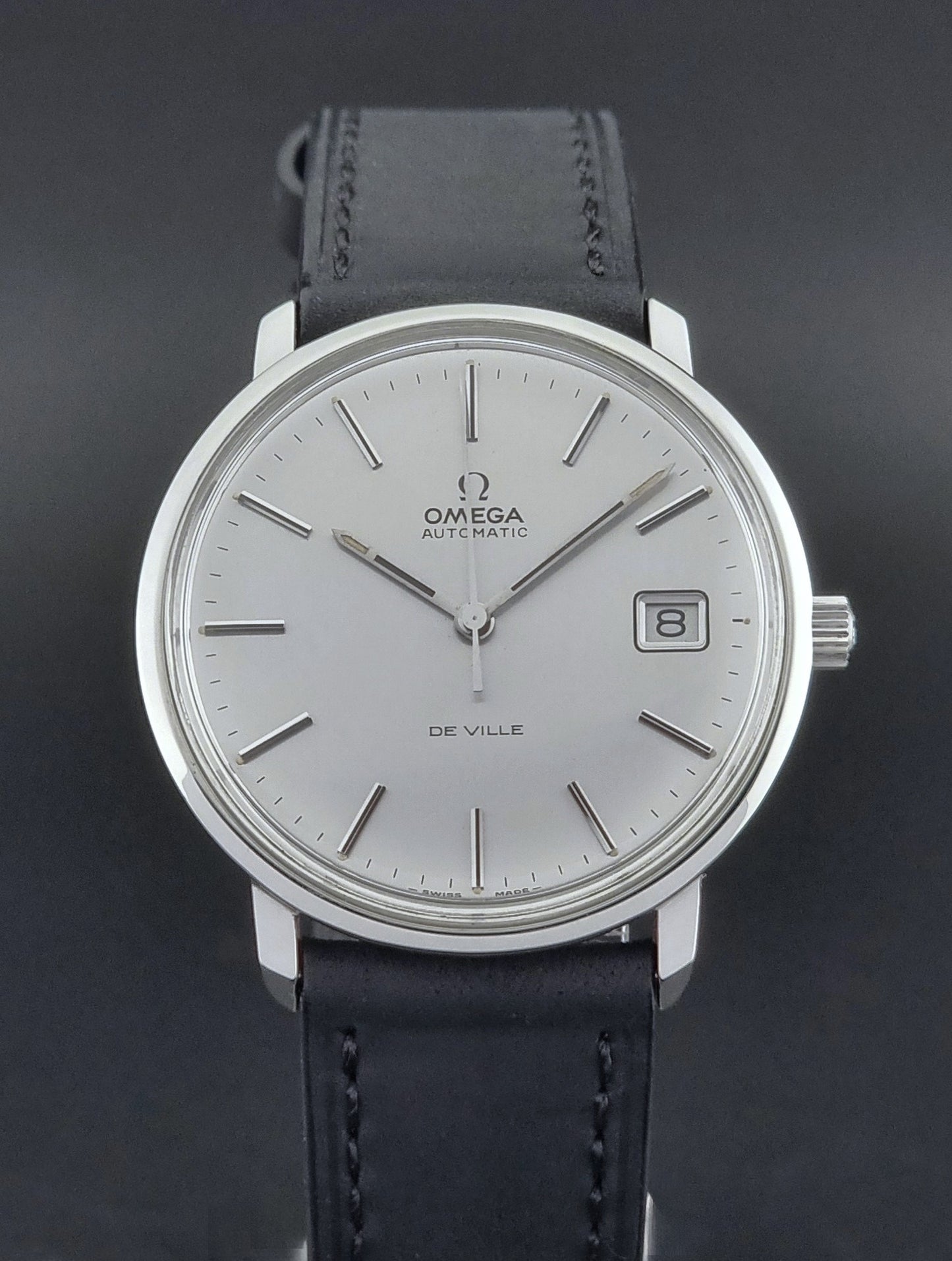 Vintage Omega de-ville wristwatch on a brown background dial view