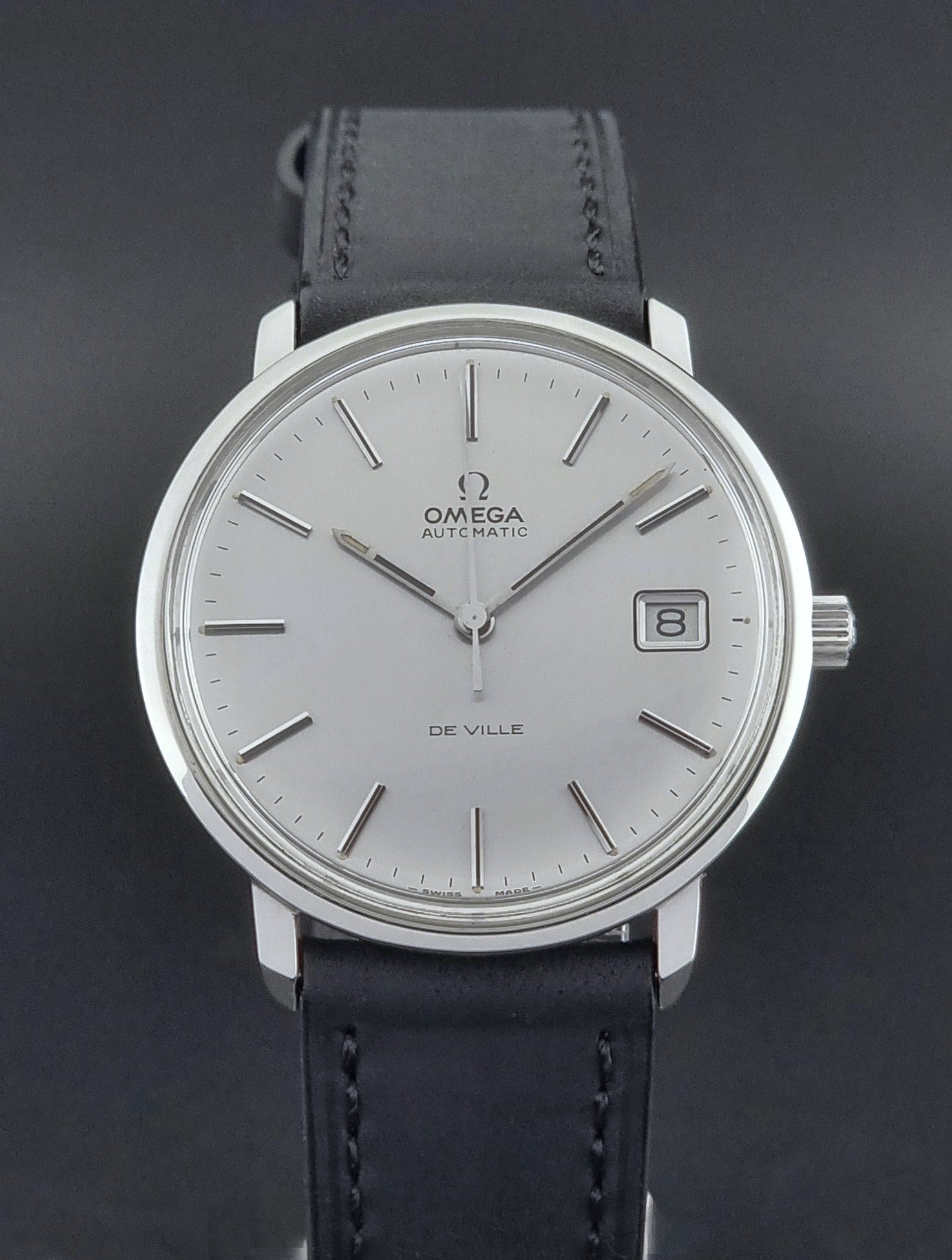 Vintage Omega de-ville wristwatch on a brown background dial view