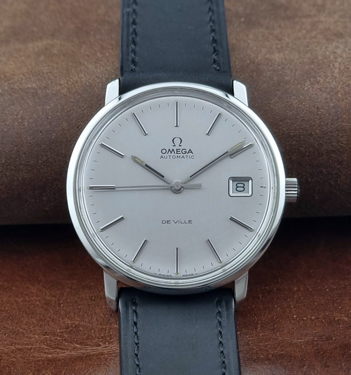 Vintage Omega de-ville wristwatch on a brown background close front view