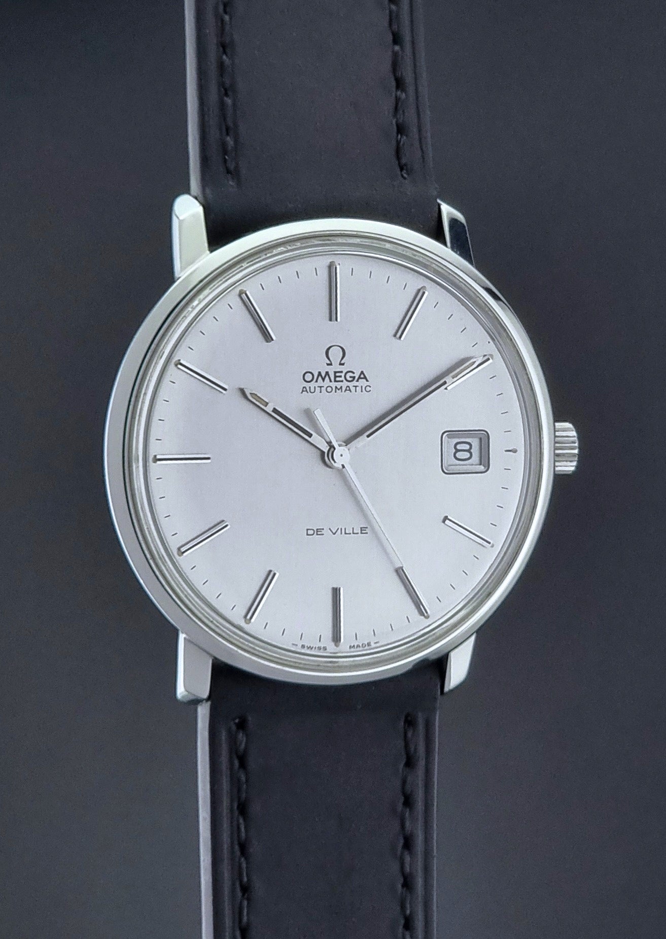 Vintage Omega de-ville wristwatch on a dark background side profile