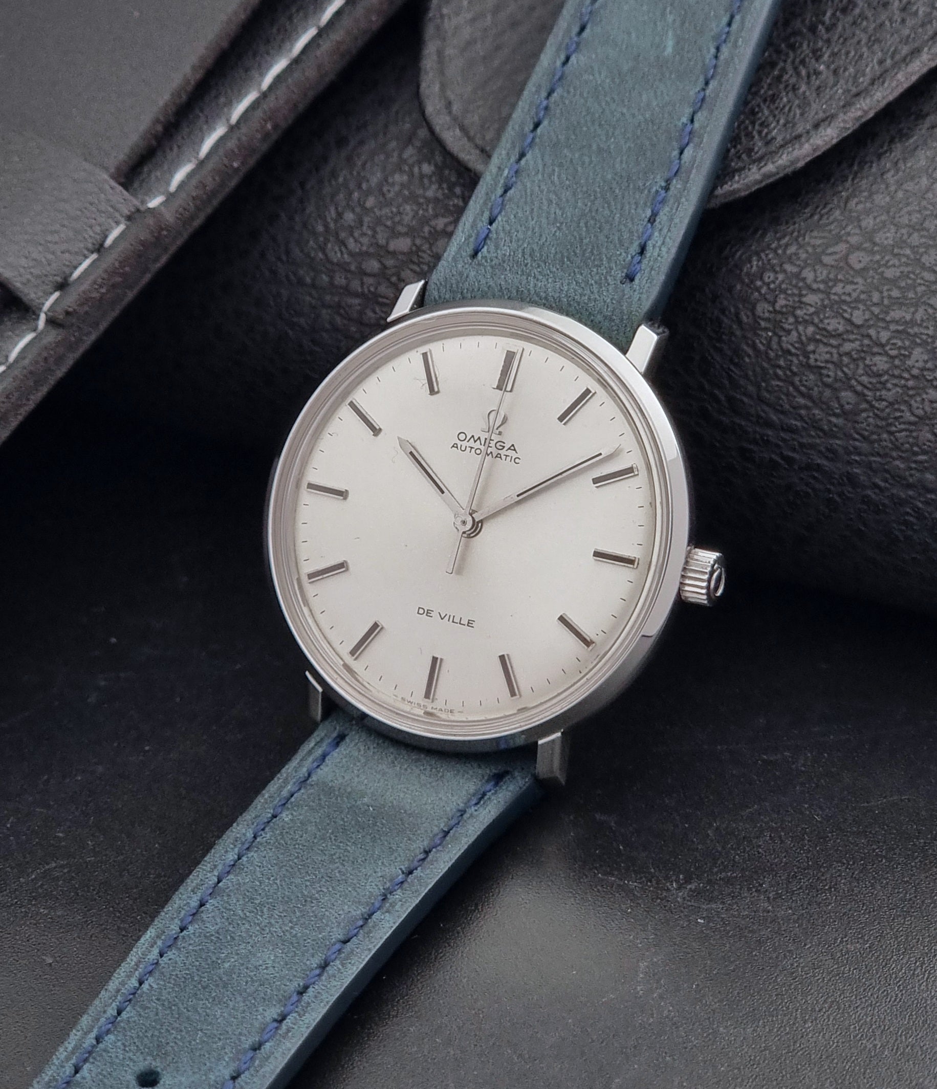 Vintage Omega Wristwatch De-Ville 165.033 with blue strap on a dark background crown view
