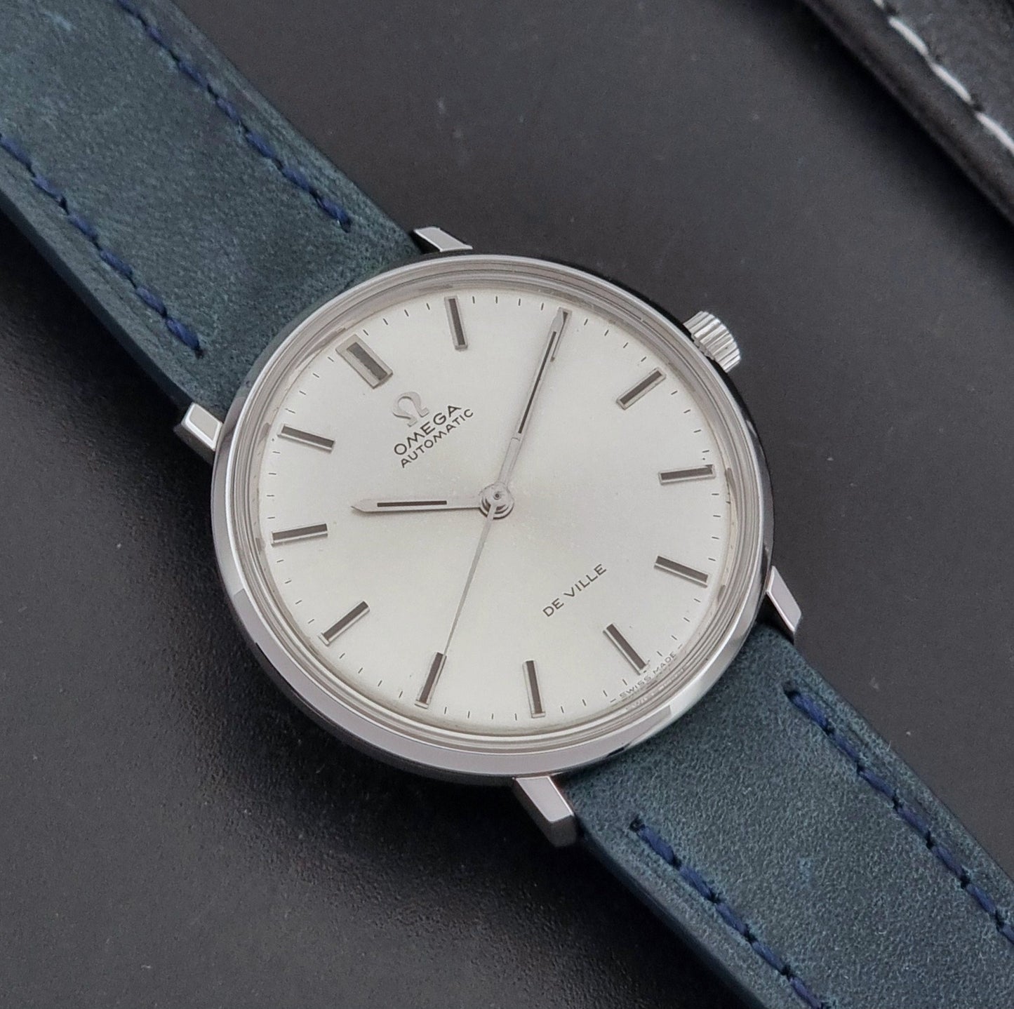 Vintage Omega Wristwatch De-Ville 165.033 with blue strap on a dark background close up dial view