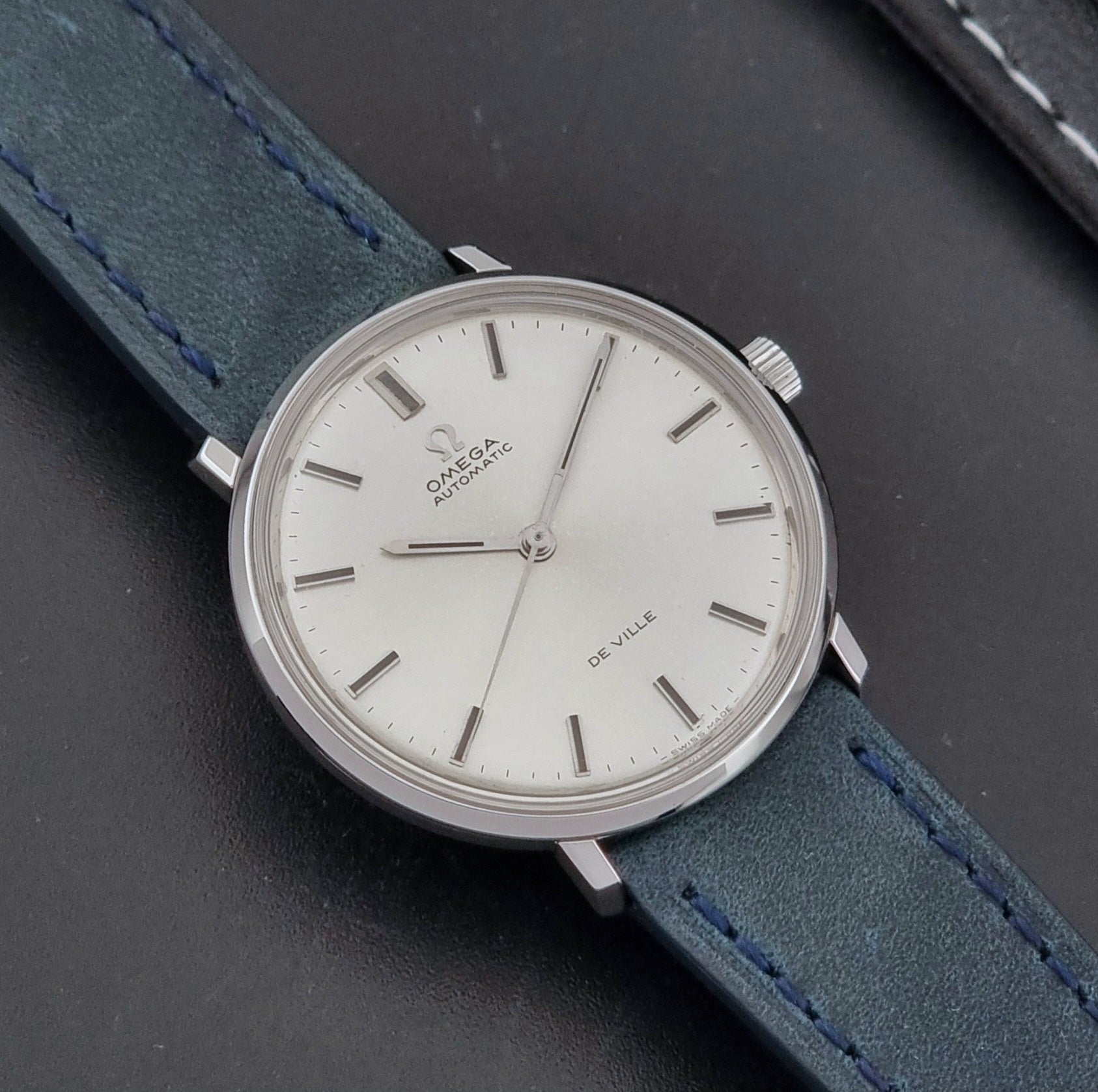 Vintage Omega Wristwatch De-Ville 165.033 with blue strap on a dark background close up dial view