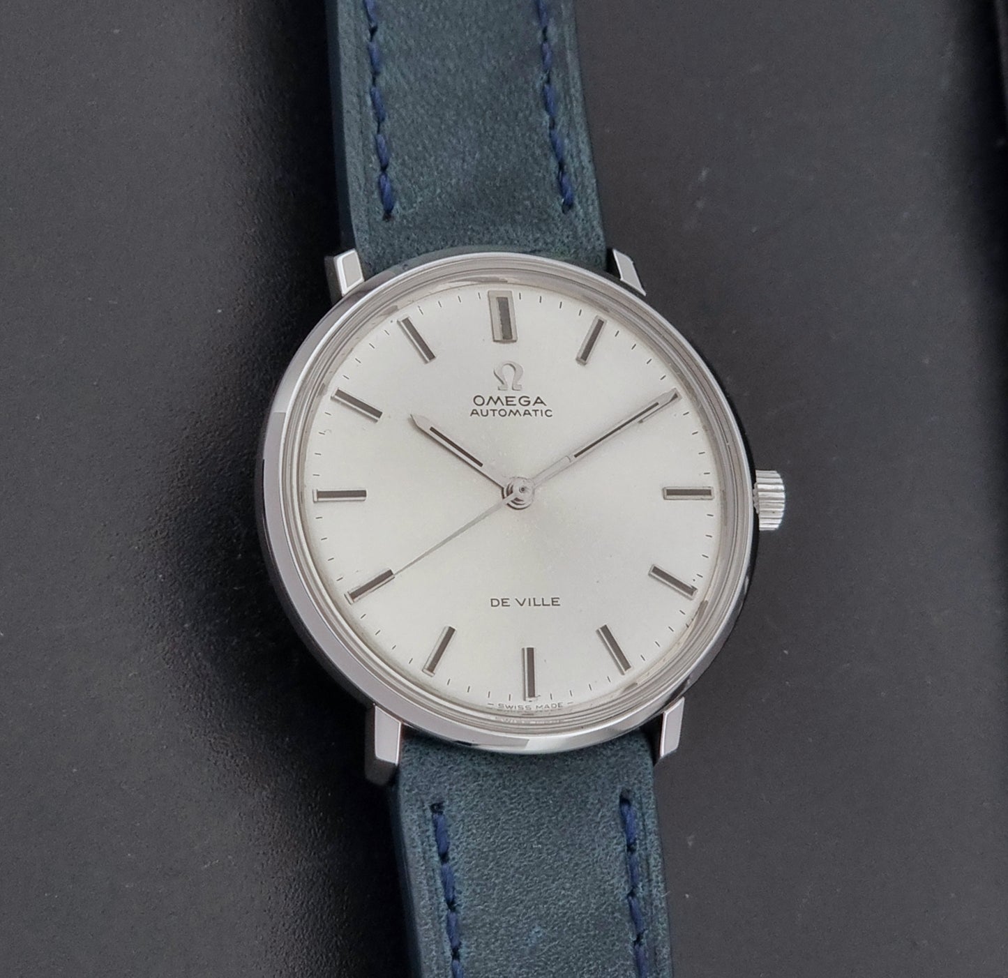 Vintage Omega Wristwatch De-Ville 165.033 with blue strap on a dark background front view