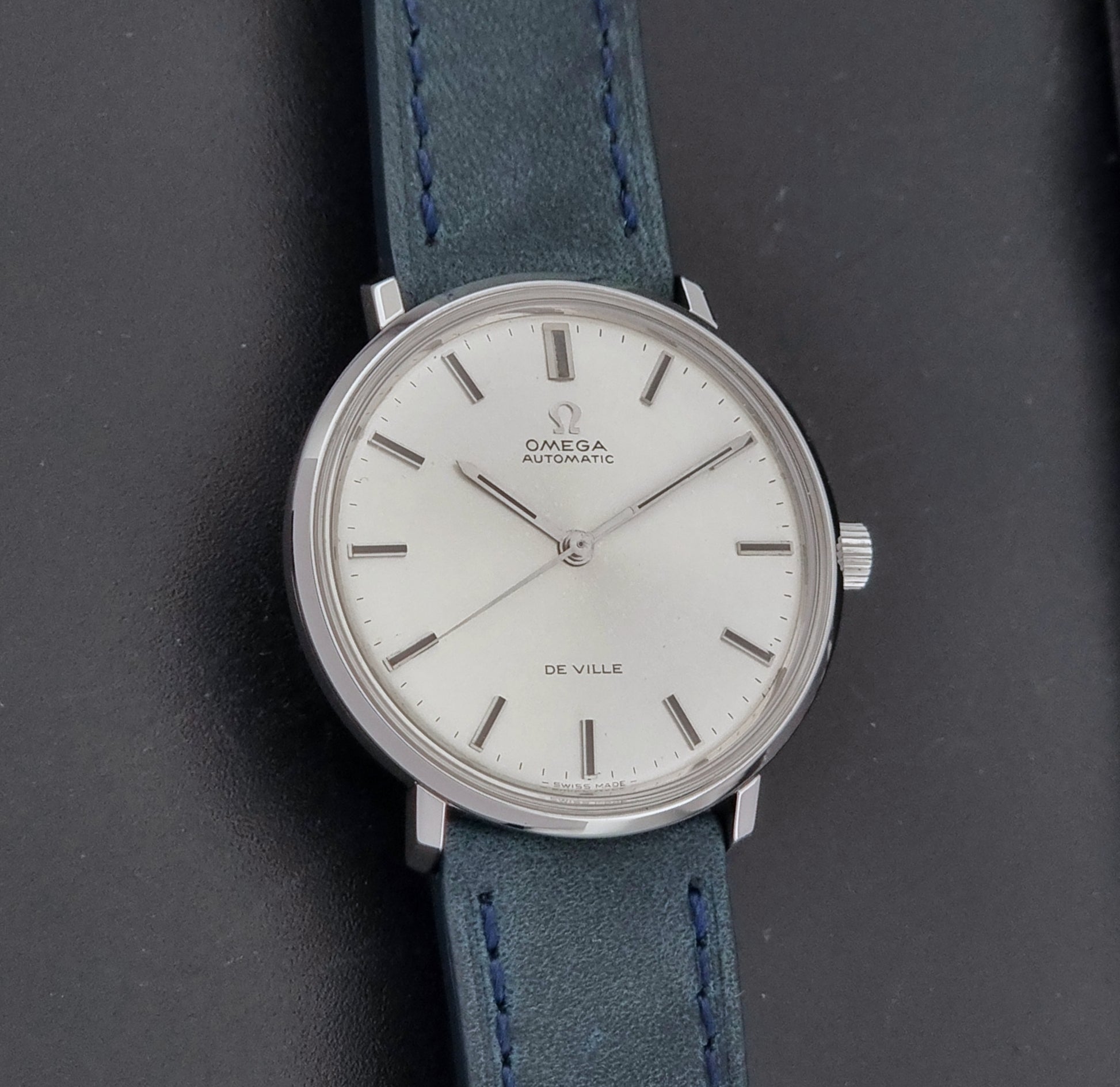 Vintage Omega Wristwatch De-Ville 165.033 with blue strap on a dark background front view
