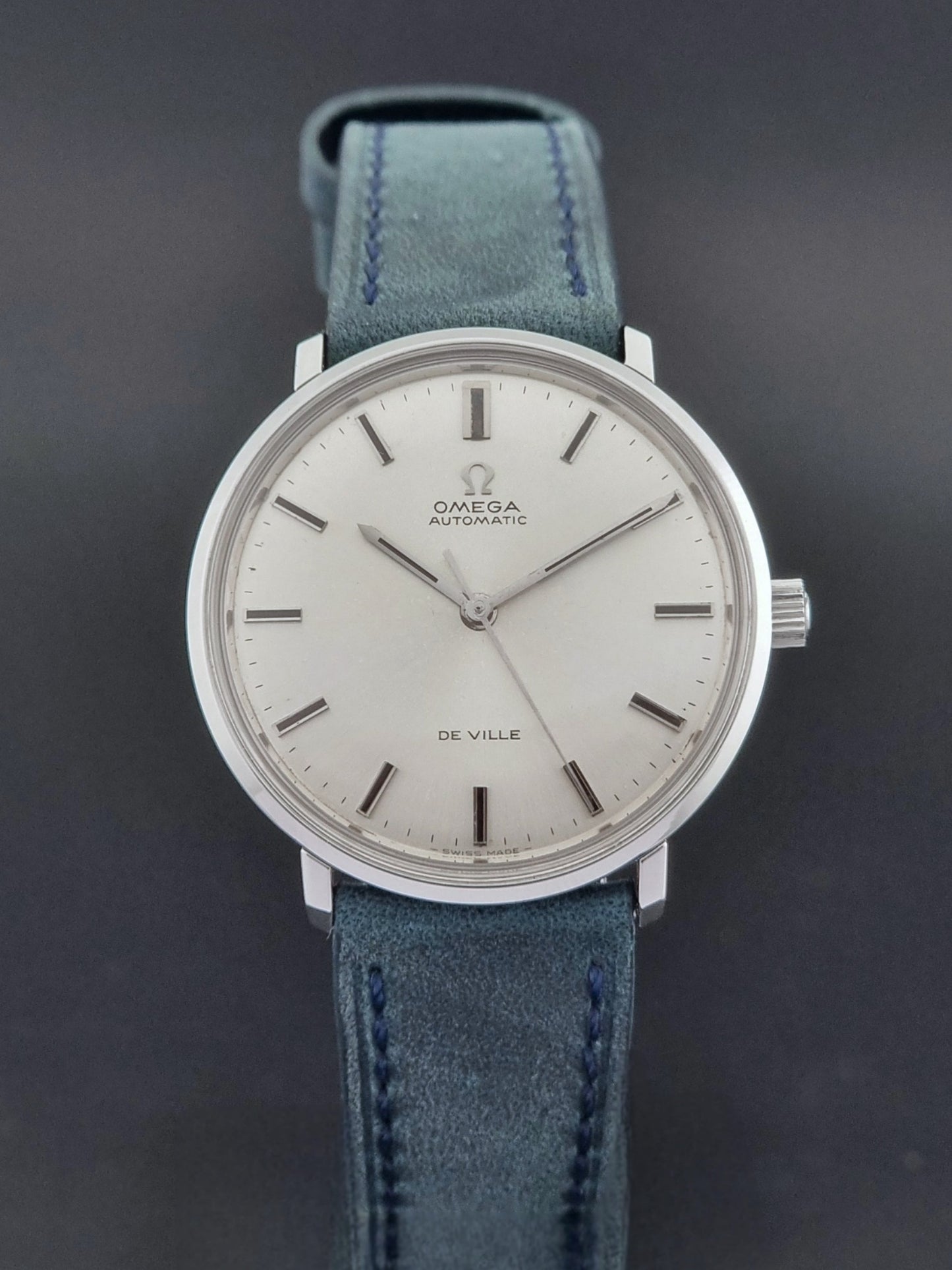 Vintage Omega Wristwatch De-Ville 165.033 with blue strap on a dark background close dial view