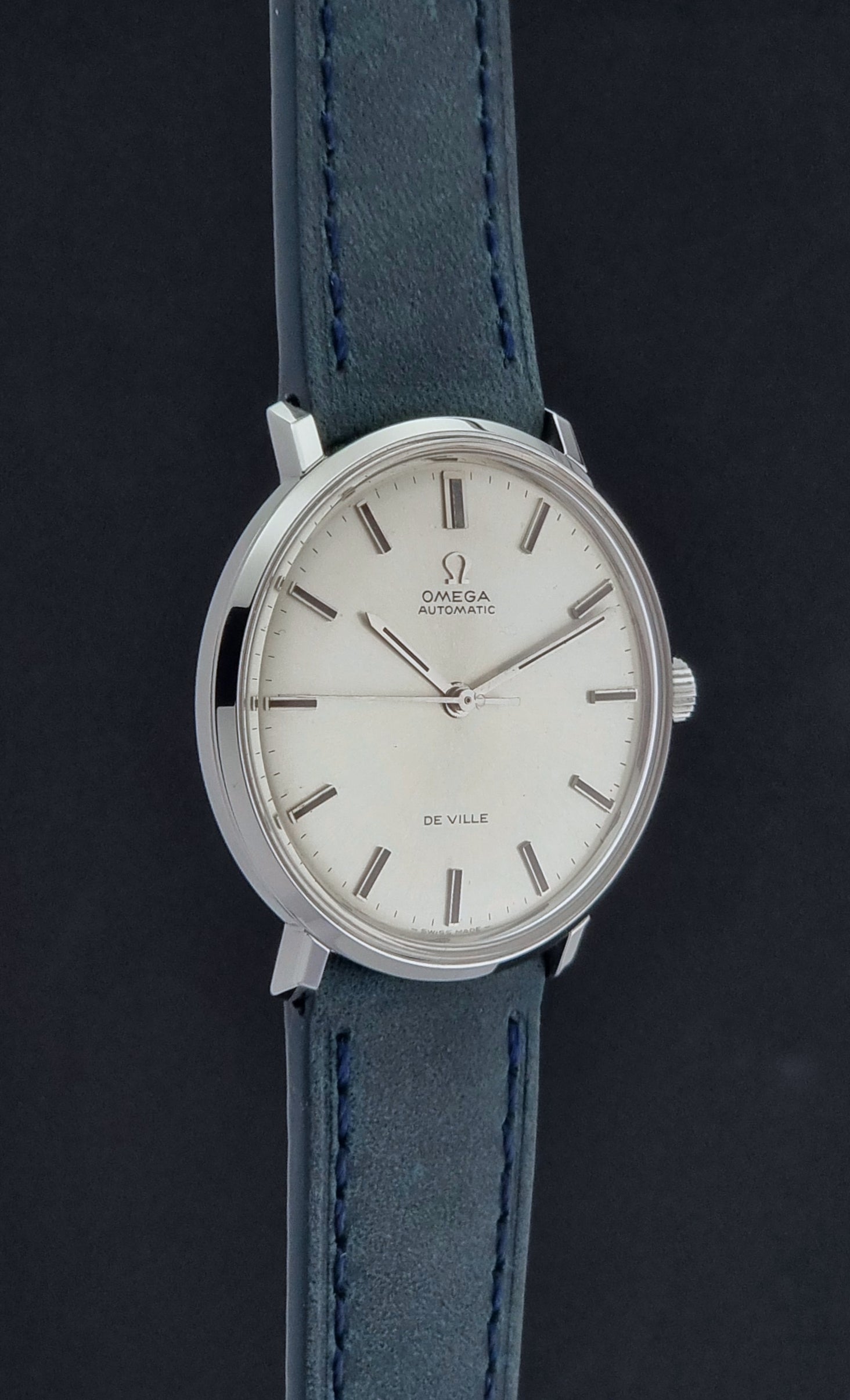 Vintage Omega Wristwatch De-Ville 165.033 with blue strap on a dark background side profile view