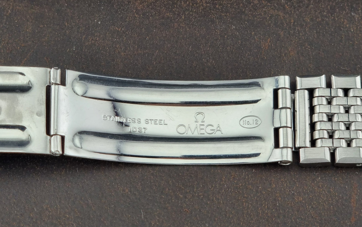 Close-up of a Omega watch band on a dark background 