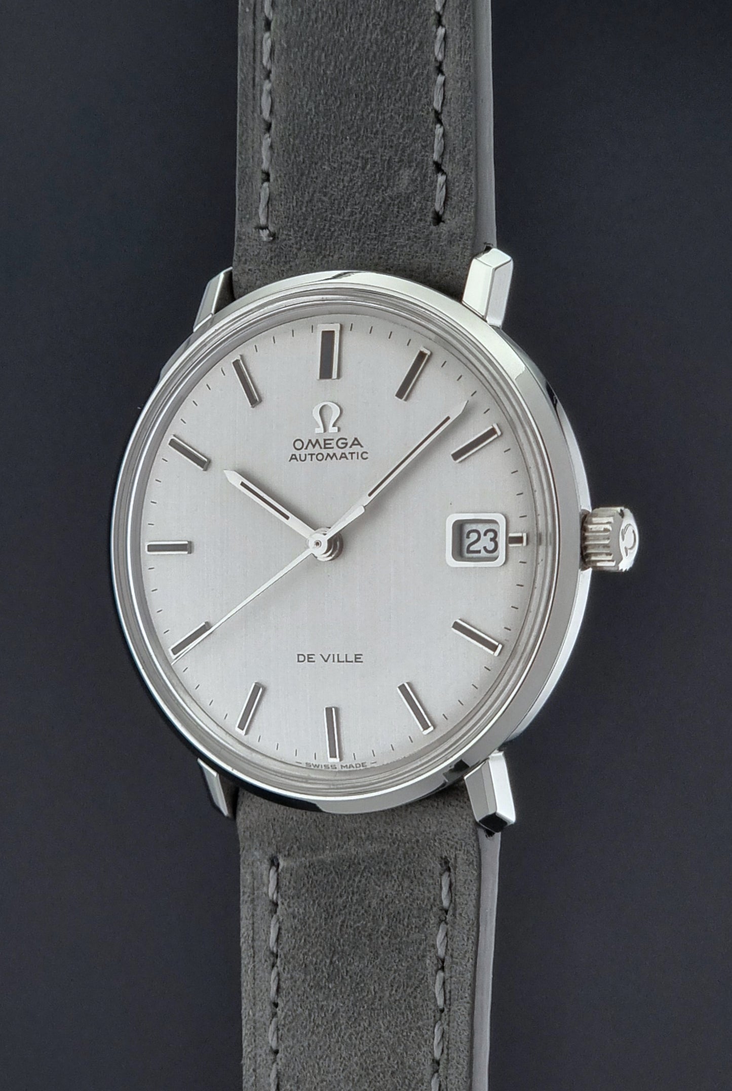 Vintage Omega Wristwatch De-Ville 166.033 with gray strap on a dark background crown side profile view