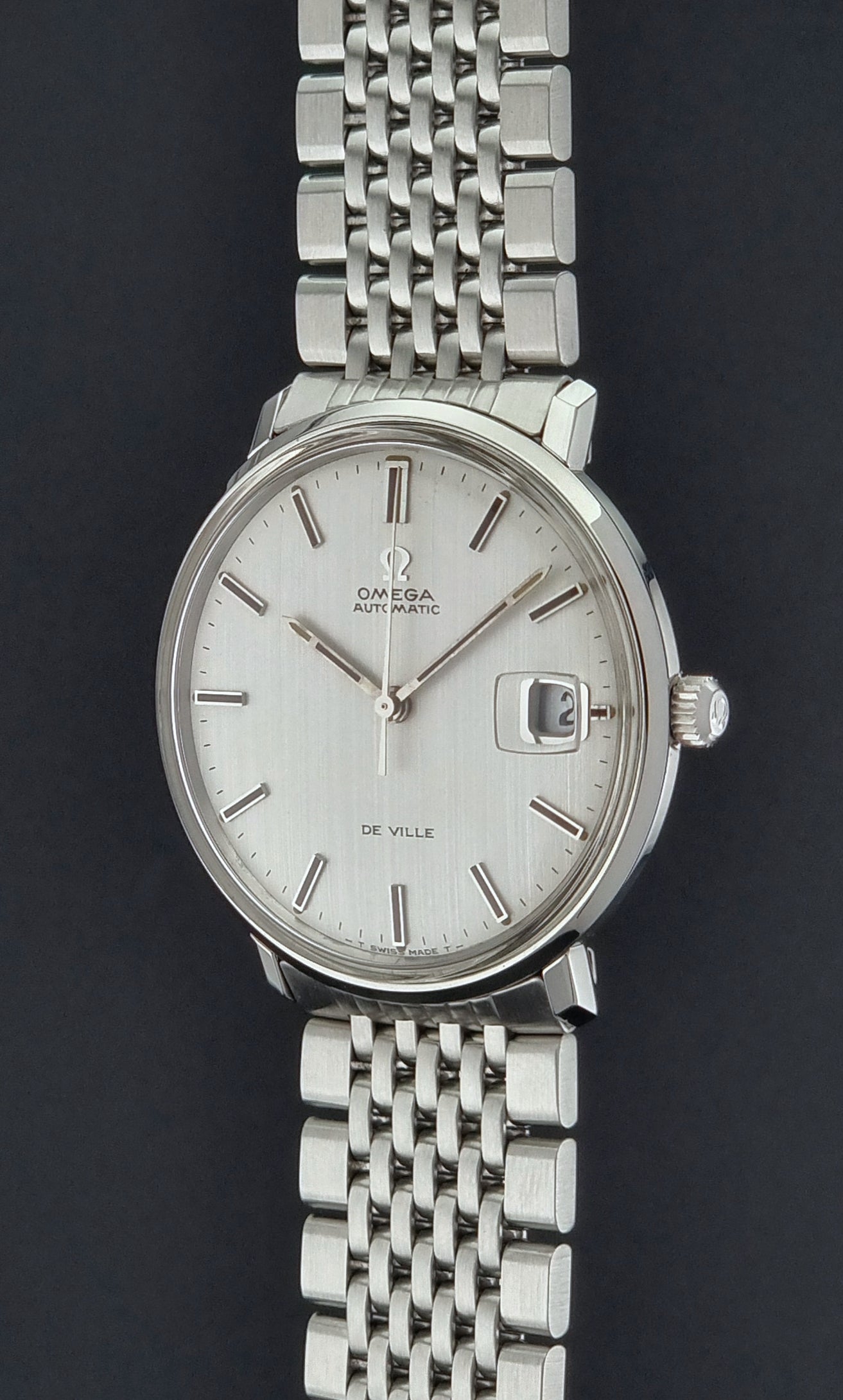 Vintage Omega De Ville watch with a white face on a black background