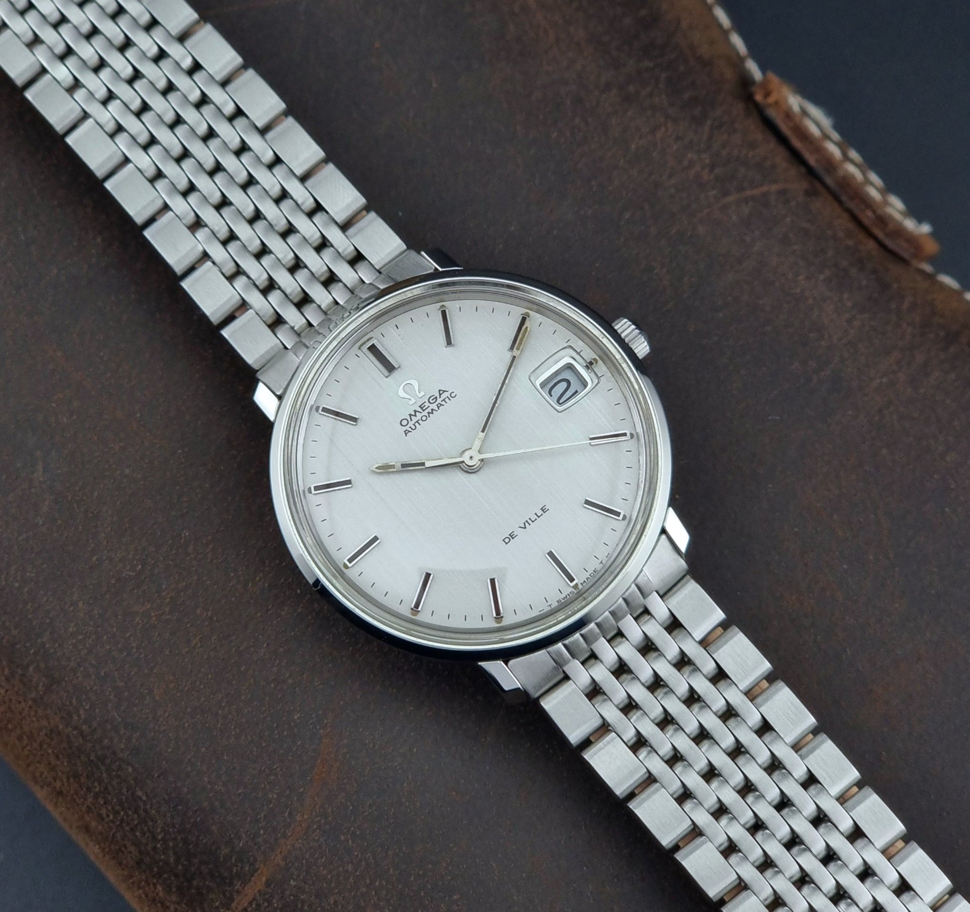 Vintage Omega De Ville watch on a brown leather background