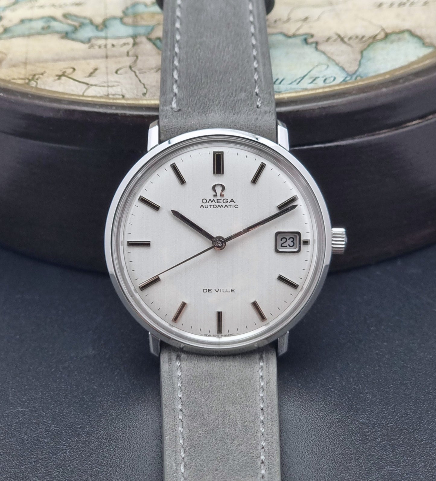 Vintage Omega Wristwatch De-Ville 166.033 with gray strap on a dark background front