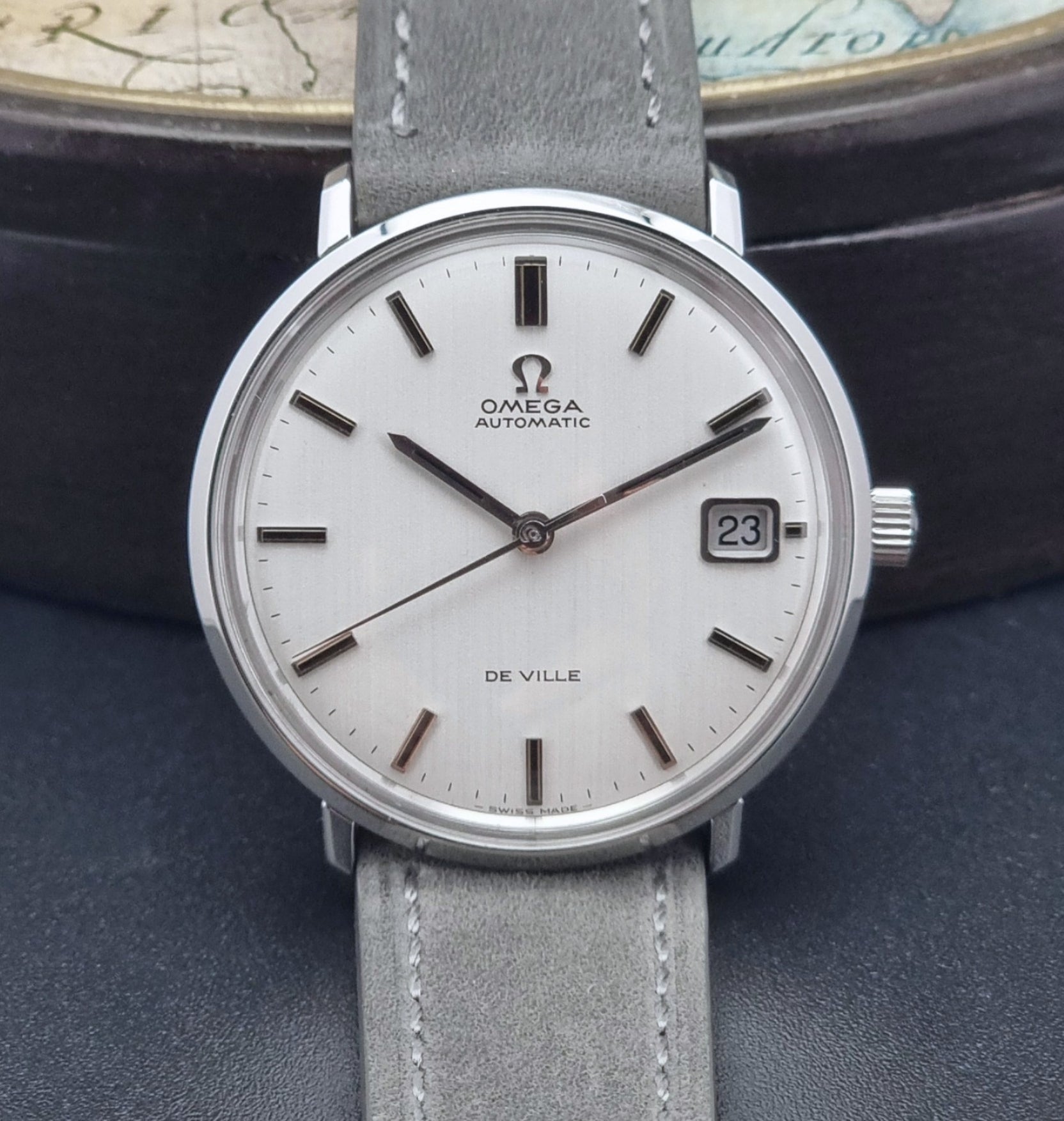 Vintage Omega Wristwatch De-Ville 166.033 with gray strap on a dark background close up front