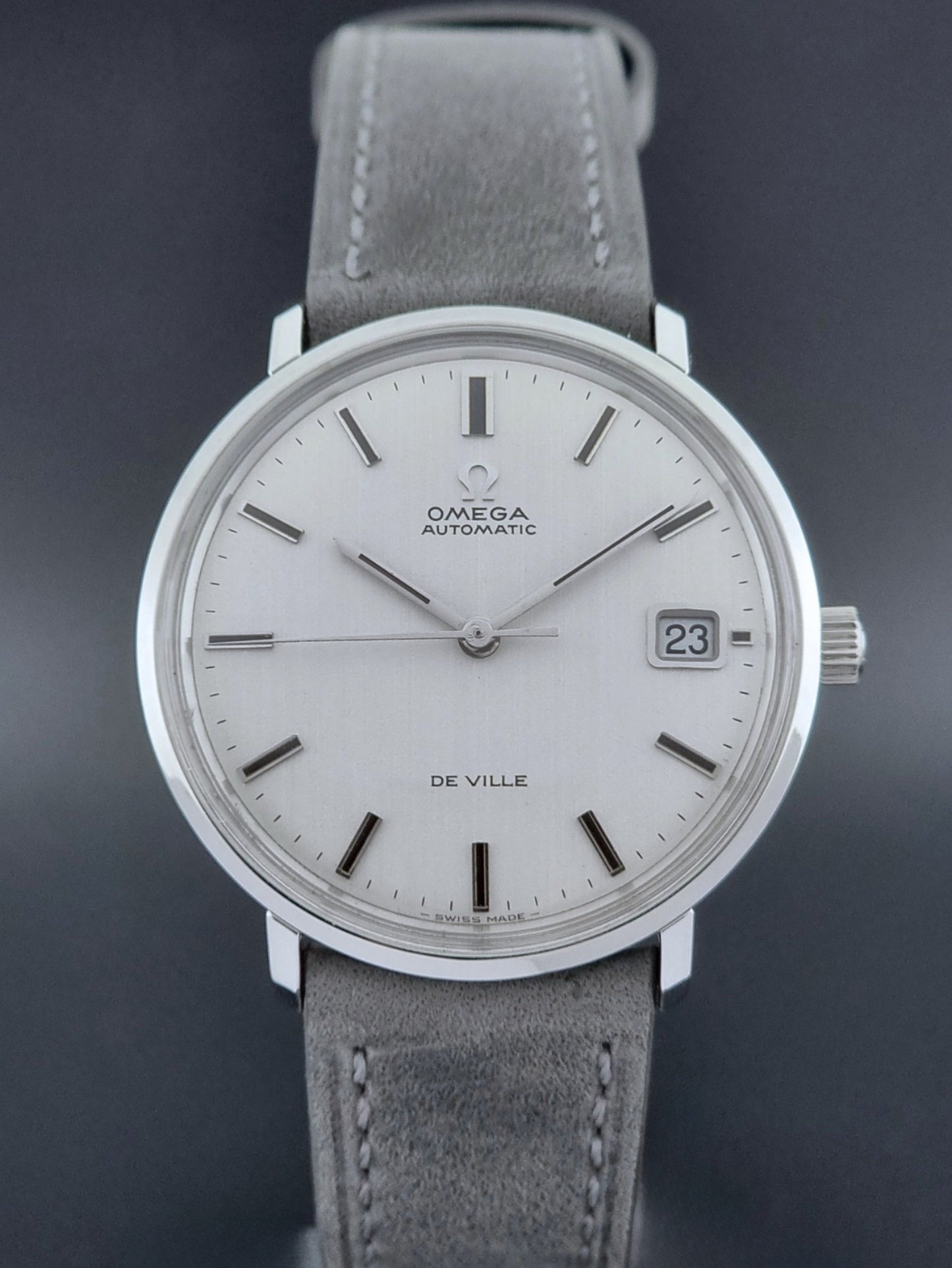 Vintage Omega Wristwatch De-Ville 166.033 with gray strap on a dark background front view