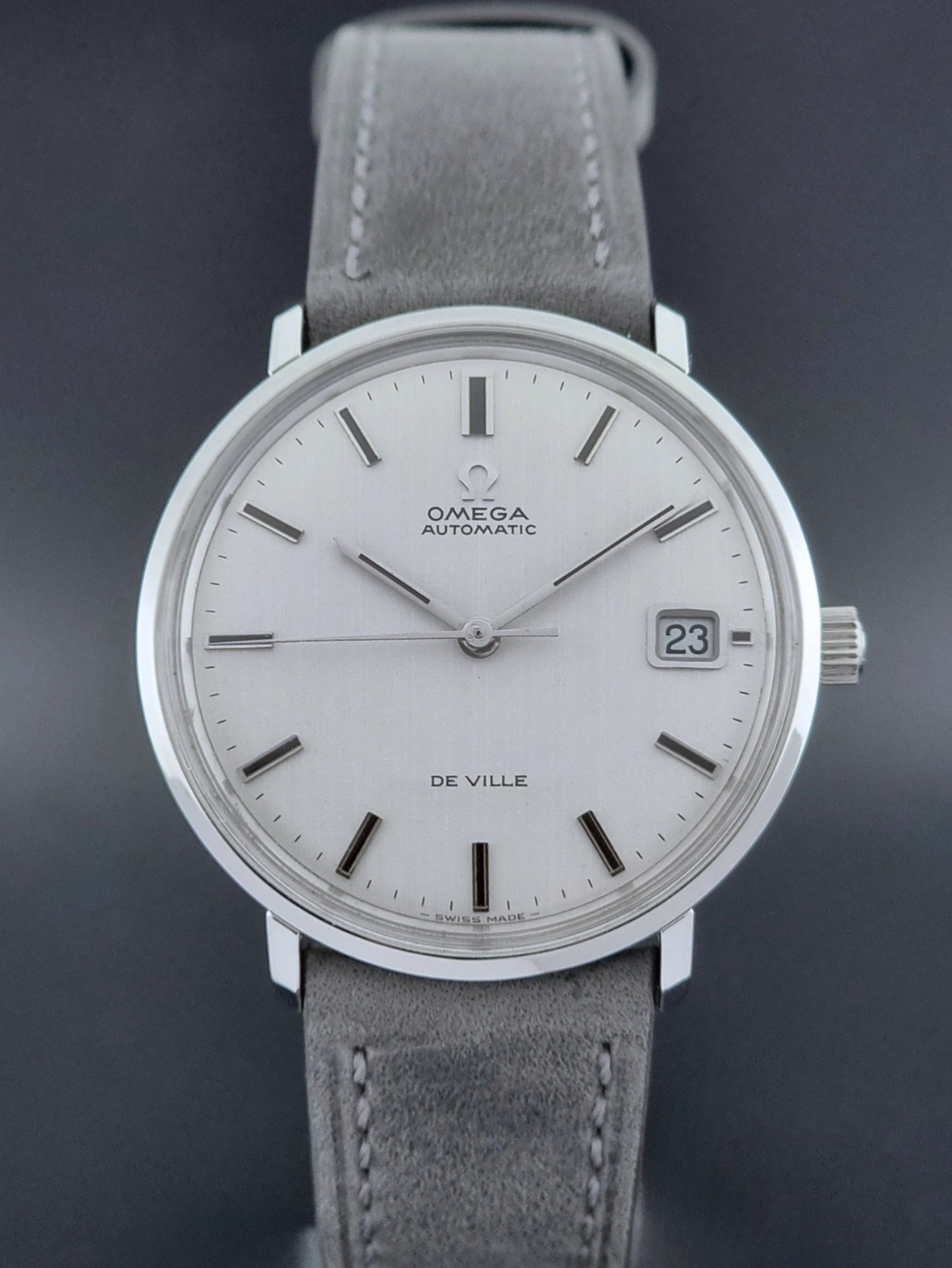 Vintage Omega Wristwatch De-Ville 166.033 with gray strap on a dark background front view