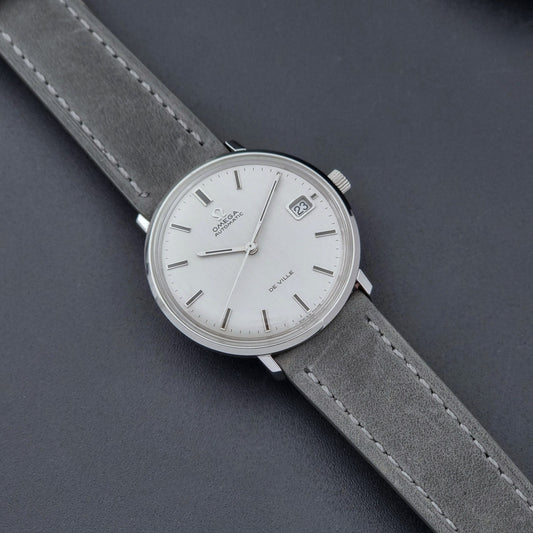 Vintage Omega Wristwatch De-Ville 166.033 with gray strap on a dark background