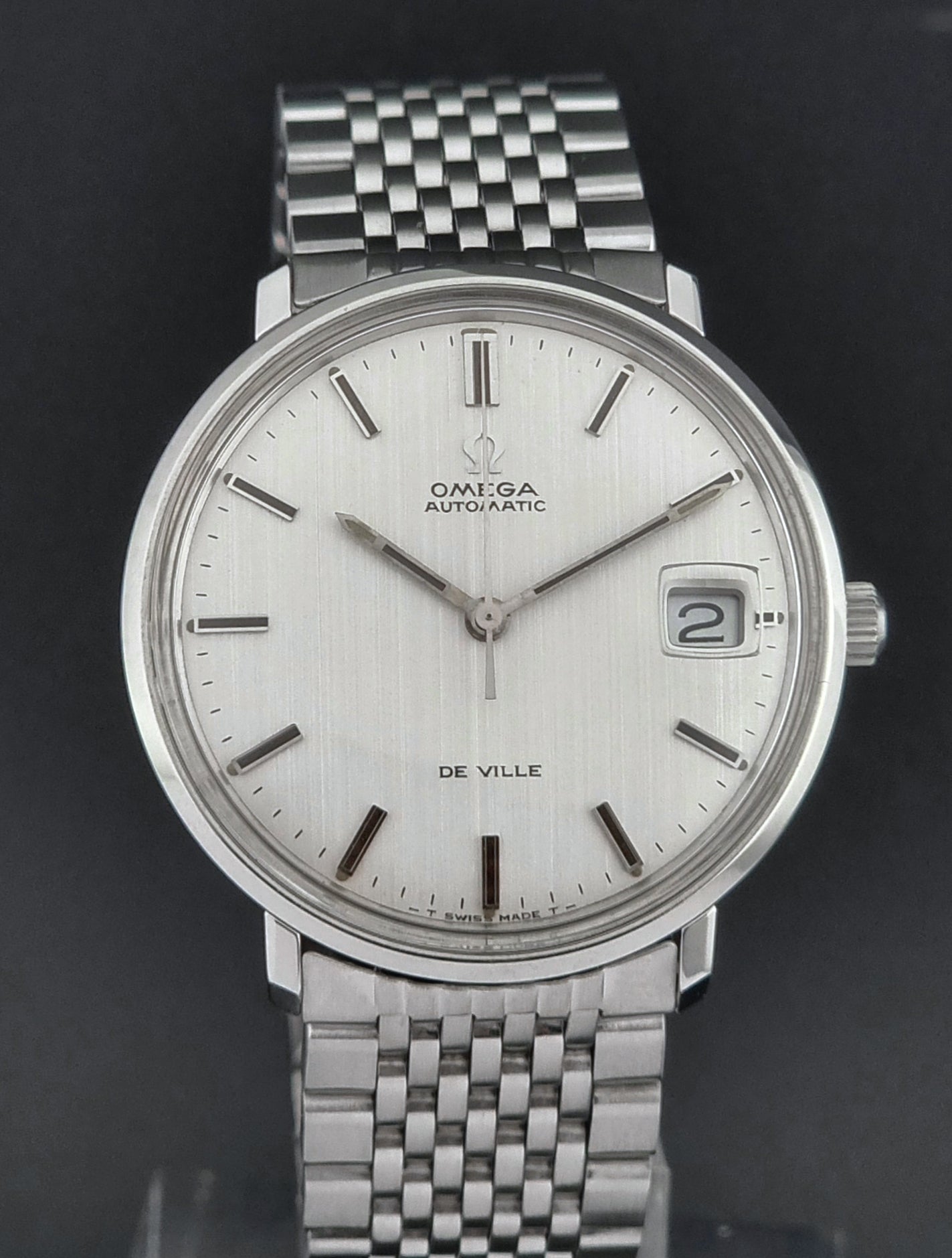 Vintage Omega De Ville watch with white face on a black background