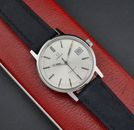 Vintage Omega Geneve watch with black strap on a red and gray background