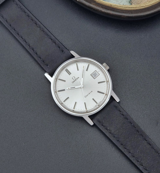 Vintage Omega Wristwatch Geneve 136.0099 with a black leather strap on a dark surface dial