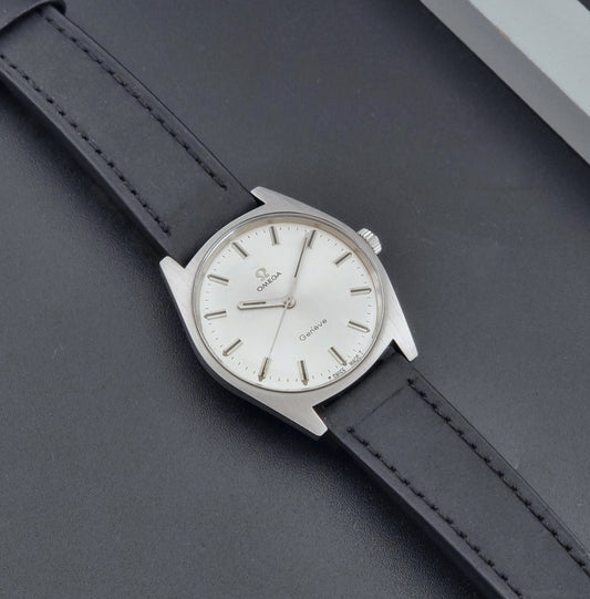 Vintage Omega watch Geneve 136.041 with a black leather strap on a dark gray background dial