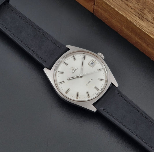 Vintage Omega watch Geneve 136.041 watch with black leather strap on a dark surface dial