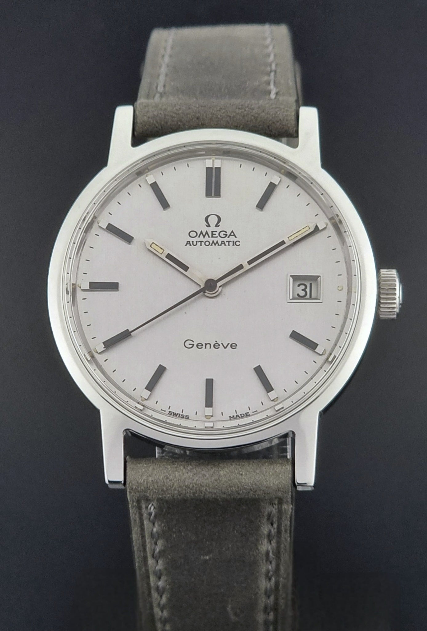 Vintage Omega Wristwatch Geneve 166.0098 with grey leather strap on a dark textured surface dial view