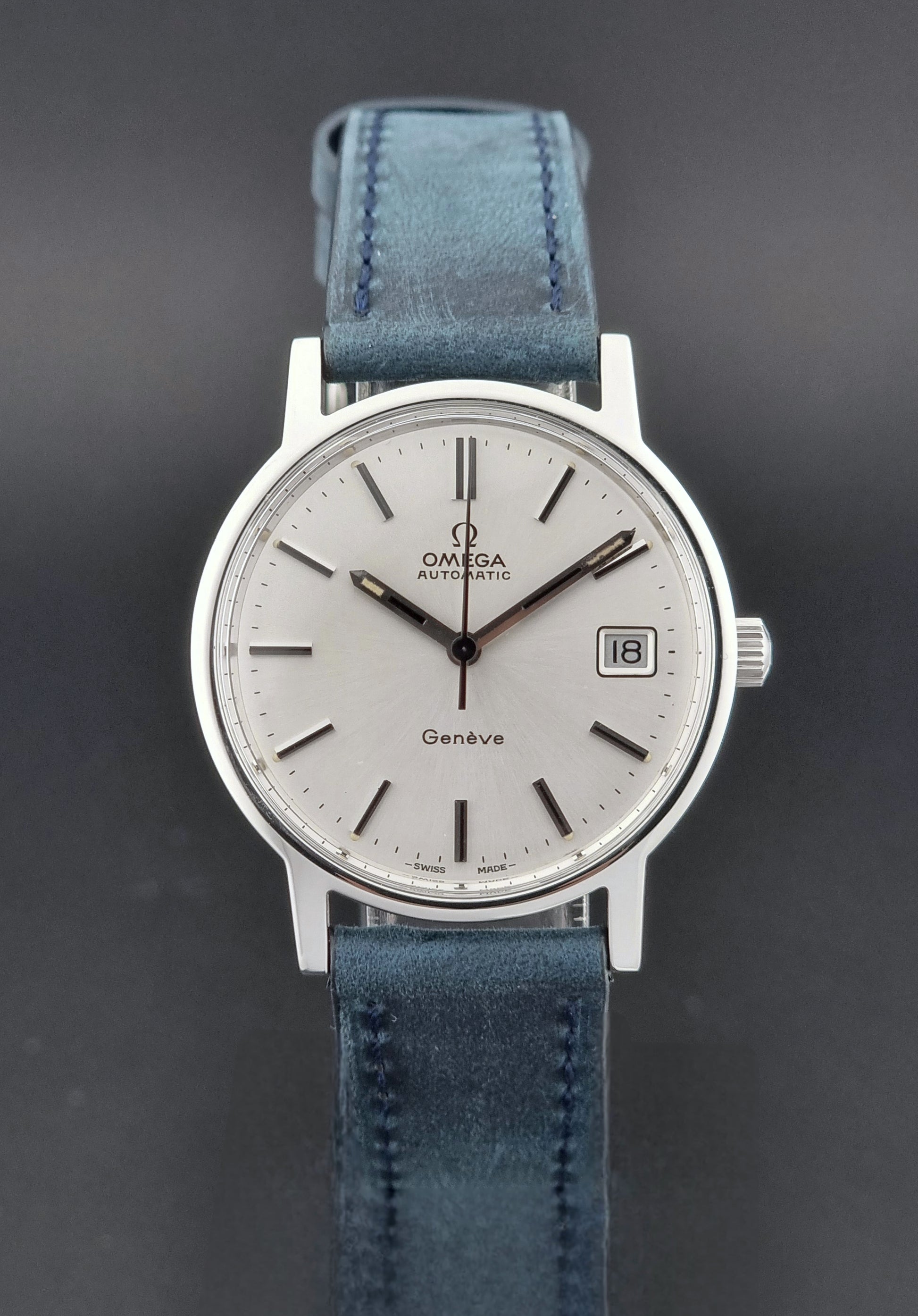 Vintage Omega Geneve 166.0163 wristwatch with blue strap on a dark background