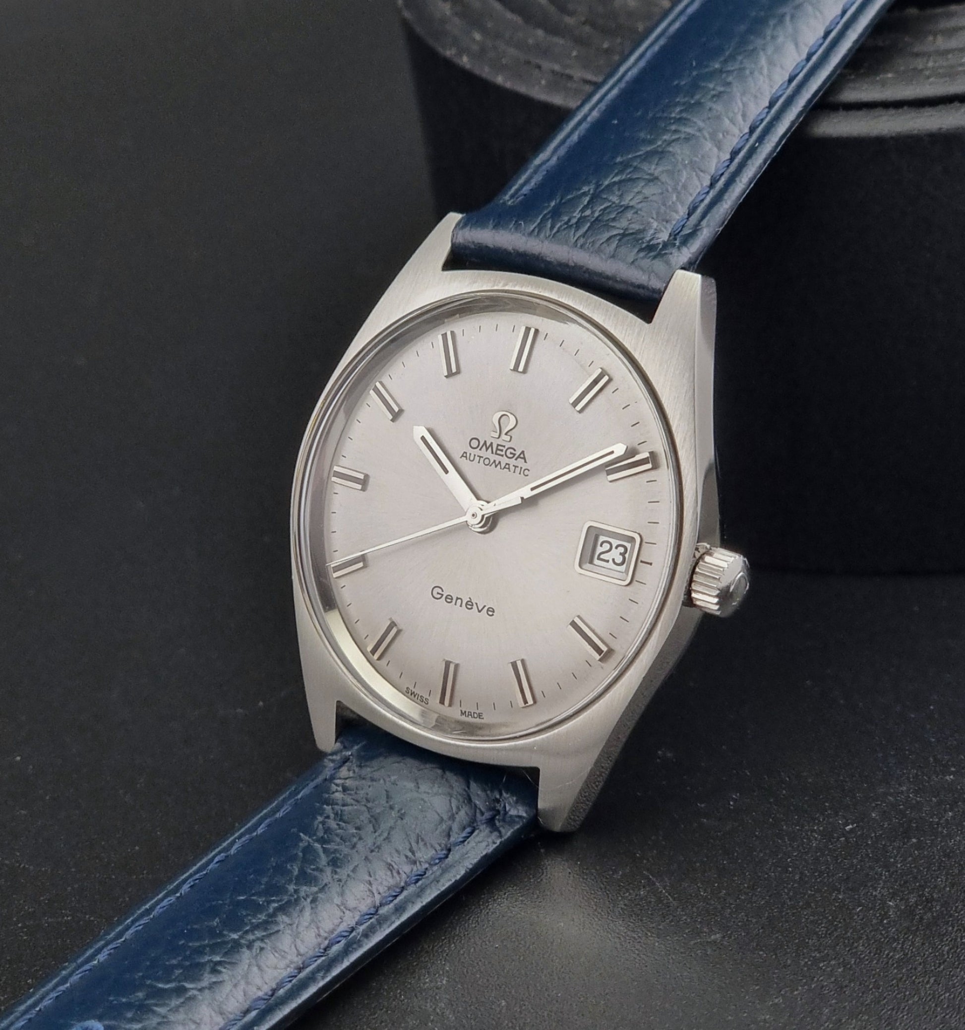 Vintage Omega Geneve watch with blue strap on a dark background