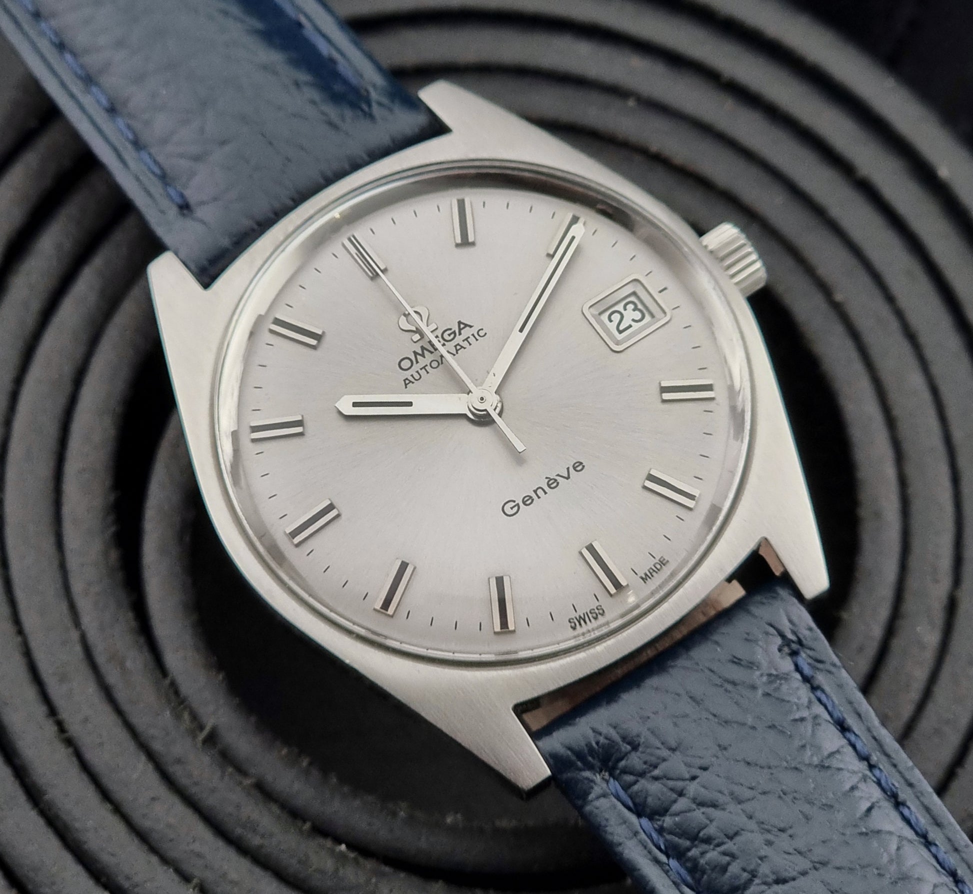 Vintage Omega Geneve watch with blue leather strap on a dark background