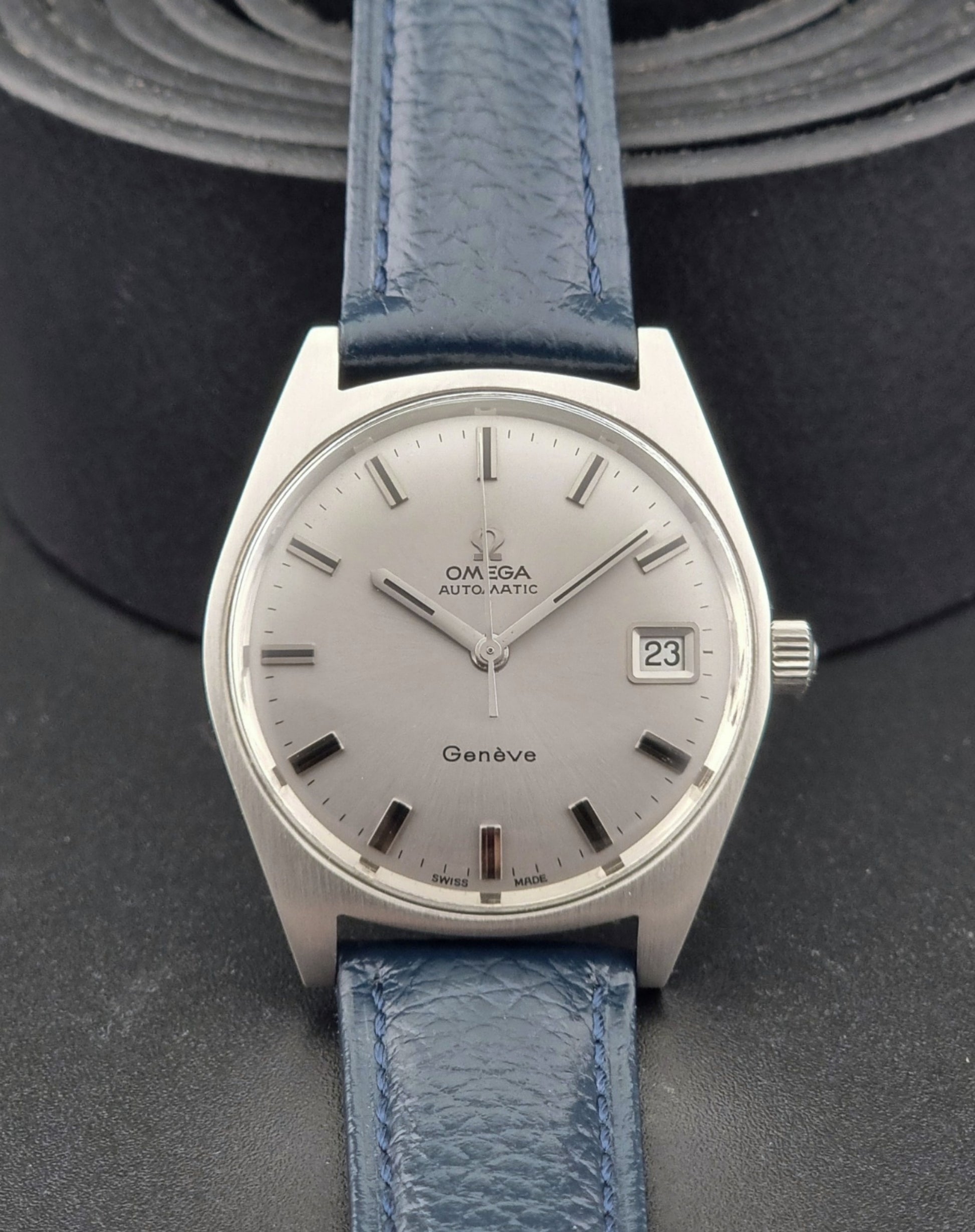 Vintage Omega Geneve watch with blue strap on a dark background