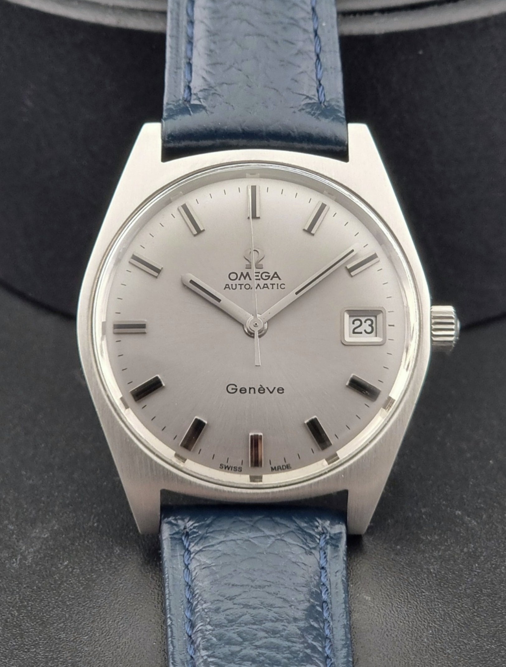 Vintage Omega Geneve watch with blue strap on a dark background