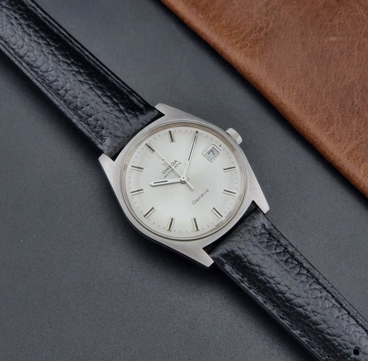 Vintage Omega Wristwatch a Geneve 166.041 with black leather strap on a dark surface dial