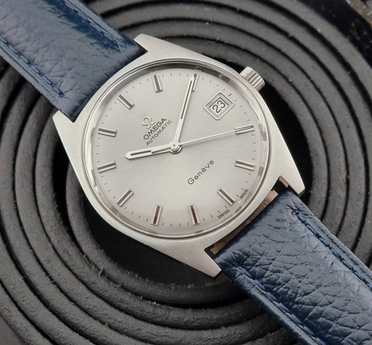 Vintage Omega Geneve watch with blue strap on a textured black background