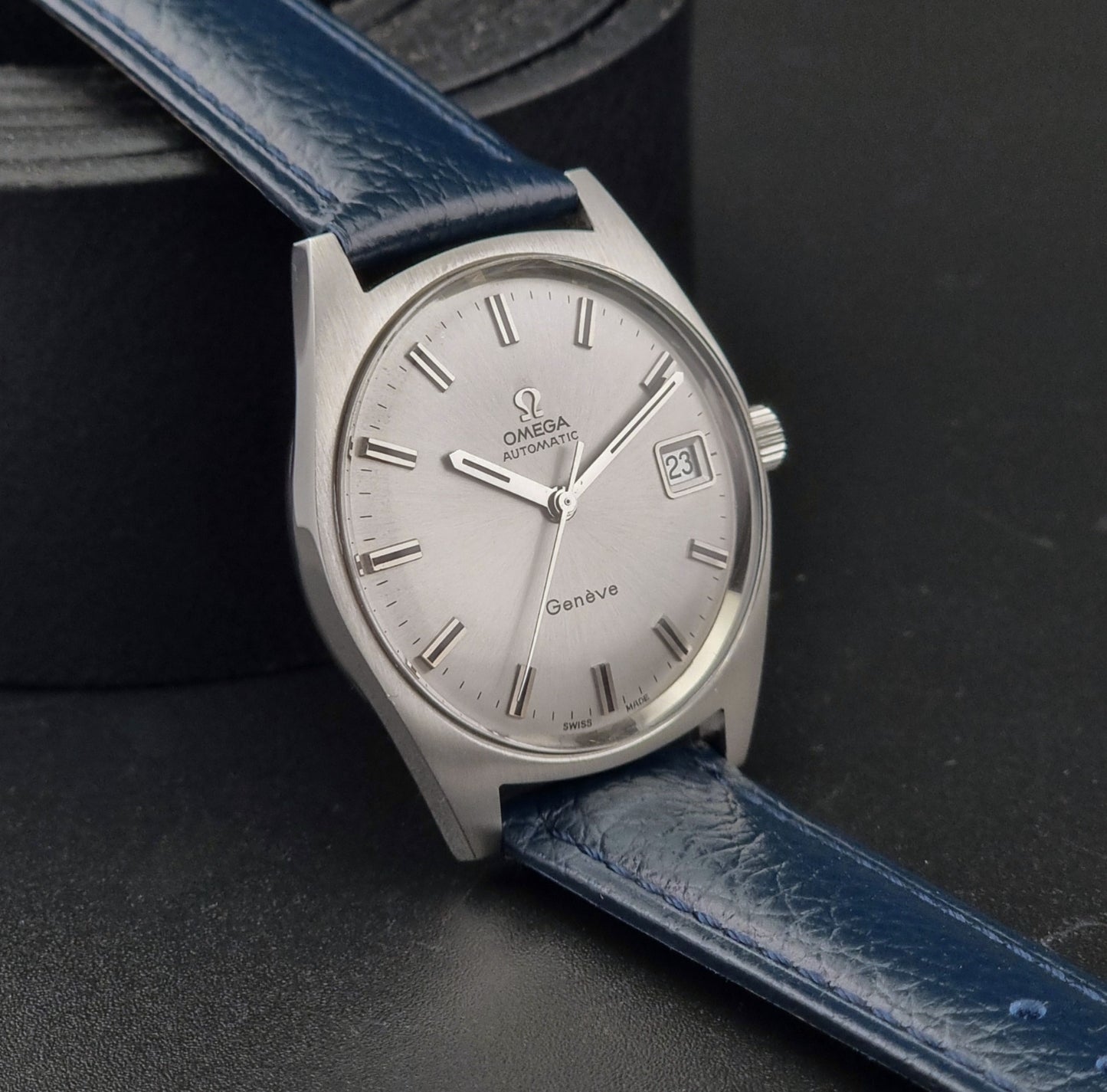 Vintage Omega Geneve watch with blue leather strap on a dark background