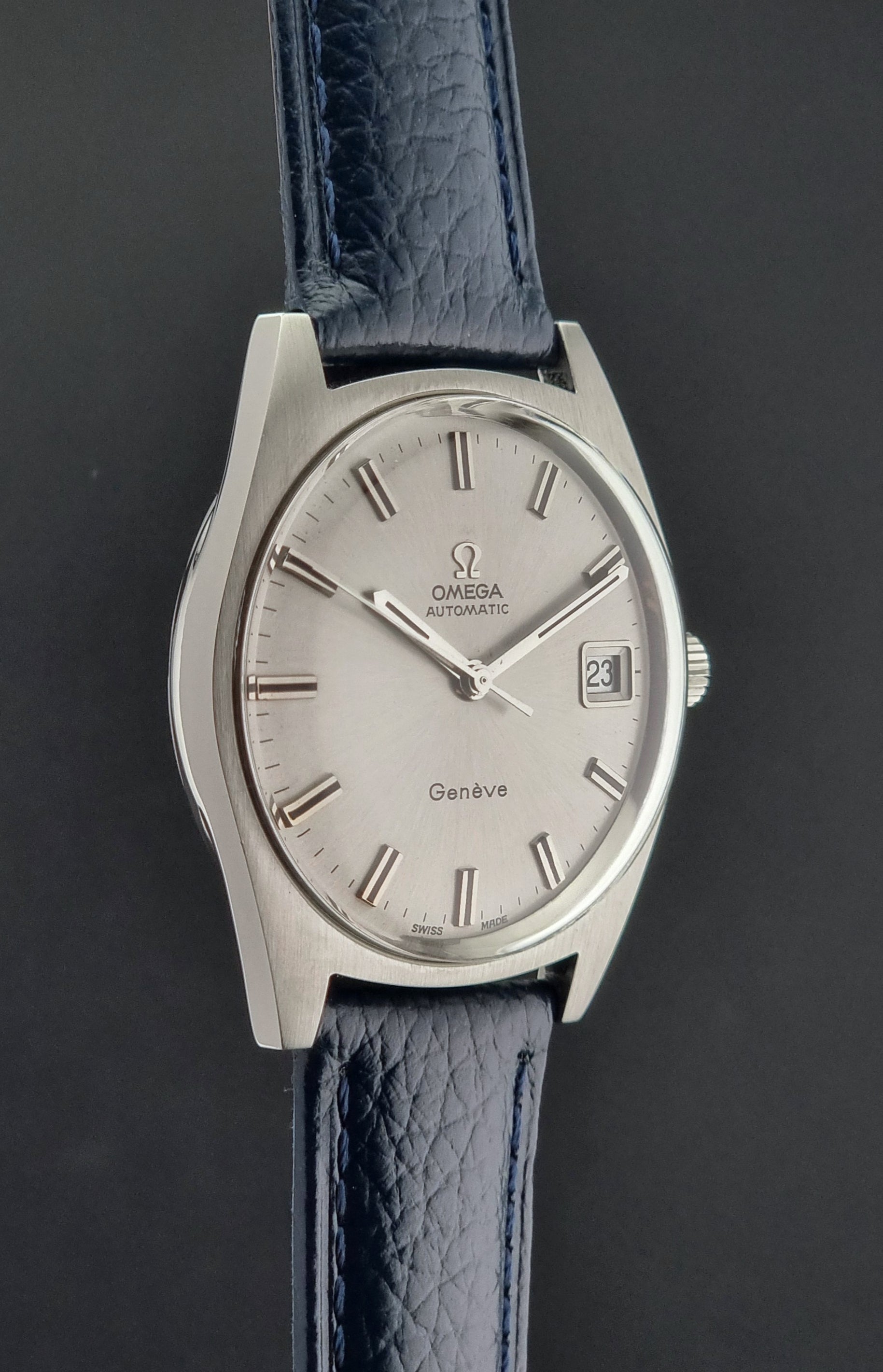 Omega watch with blue leather strap on a dark background