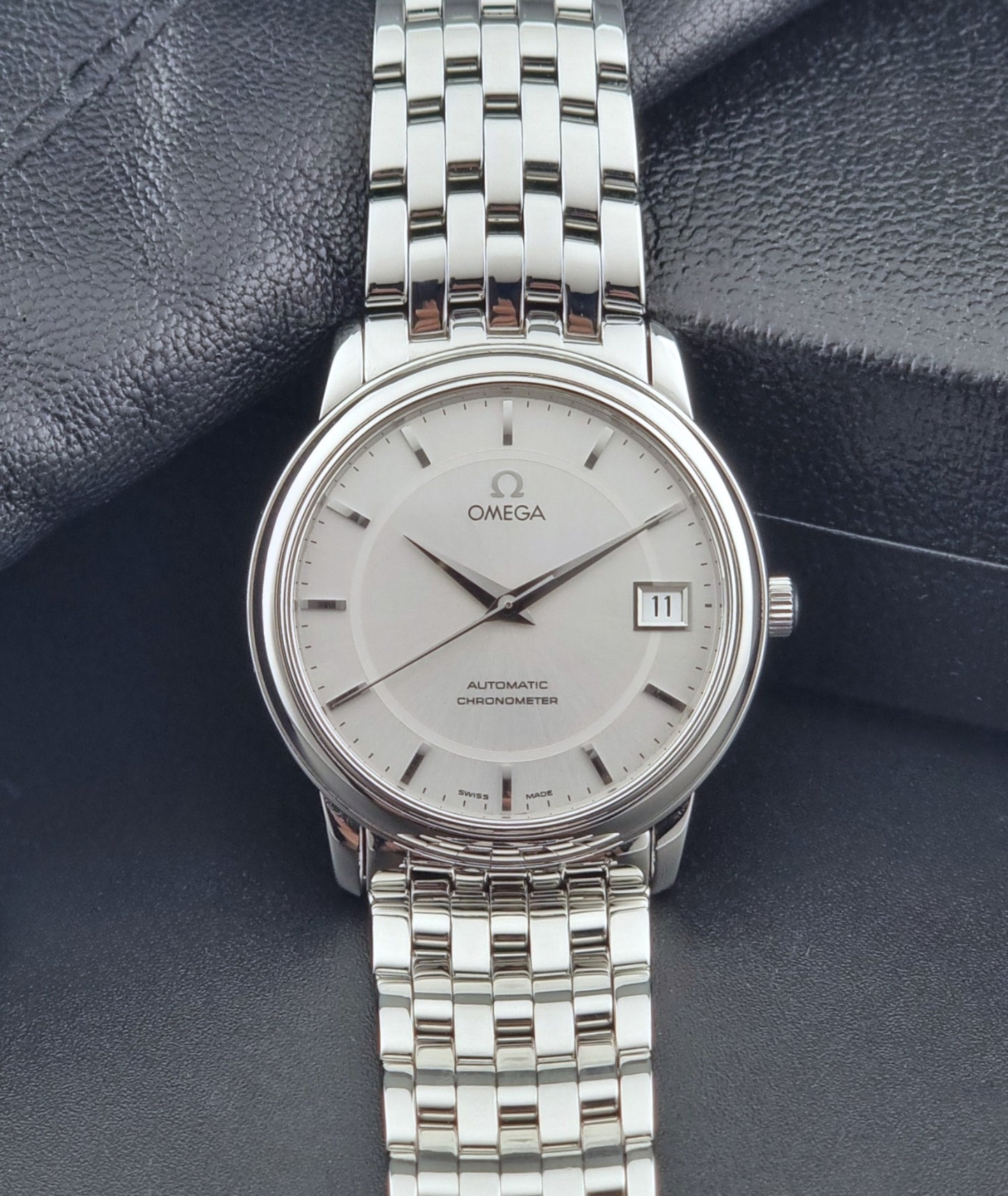 Omega watch a De-Ville Prestige 168.1050 with a stainless steel bracelet on a dark background dial view