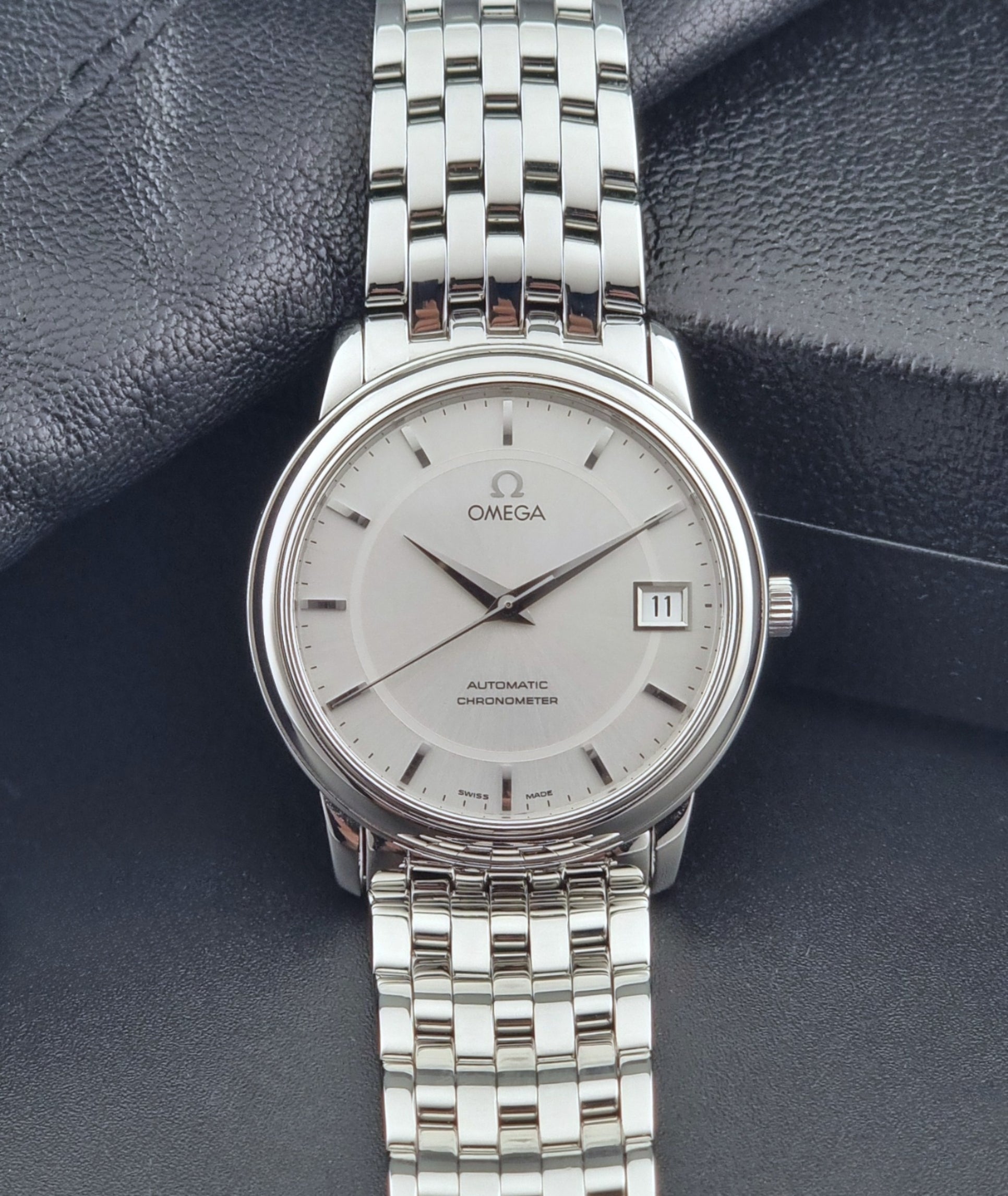 Omega watch a De-Ville Prestige 168.1050 with a stainless steel bracelet on a dark background dial view