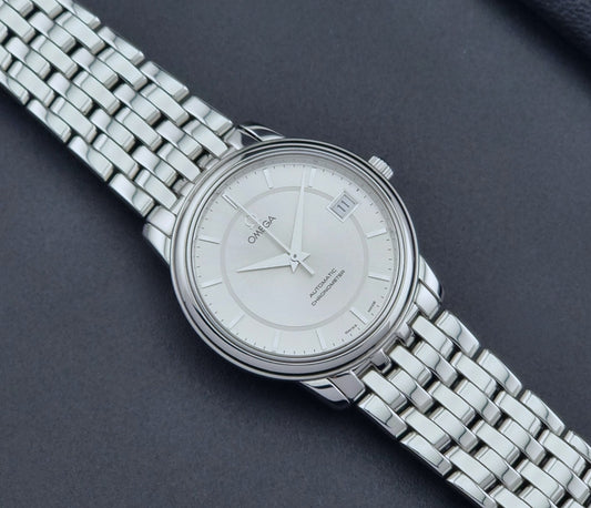Omega watch a De-Ville Prestige 168.1050 with a stainless steel bracelet on a dark background clos eup dial view