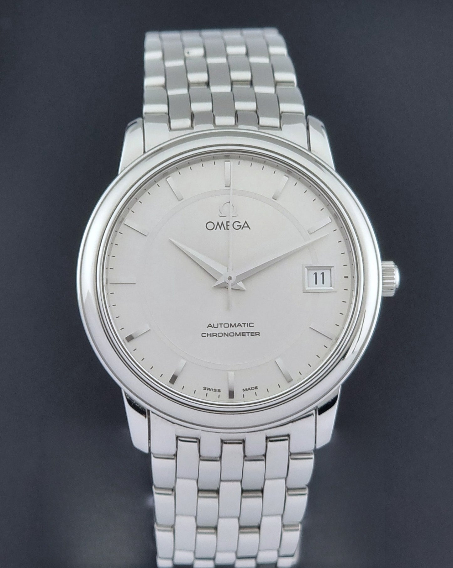 Omega watch a De-Ville Prestige 168.1050 with a stainless steel bracelet on a dark background close dial view
