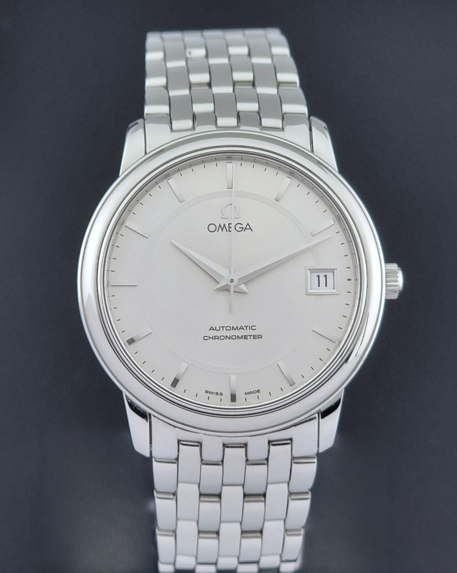 Omega watch a De-Ville Prestige 168.1050 with a stainless steel bracelet on a dark background close dial view