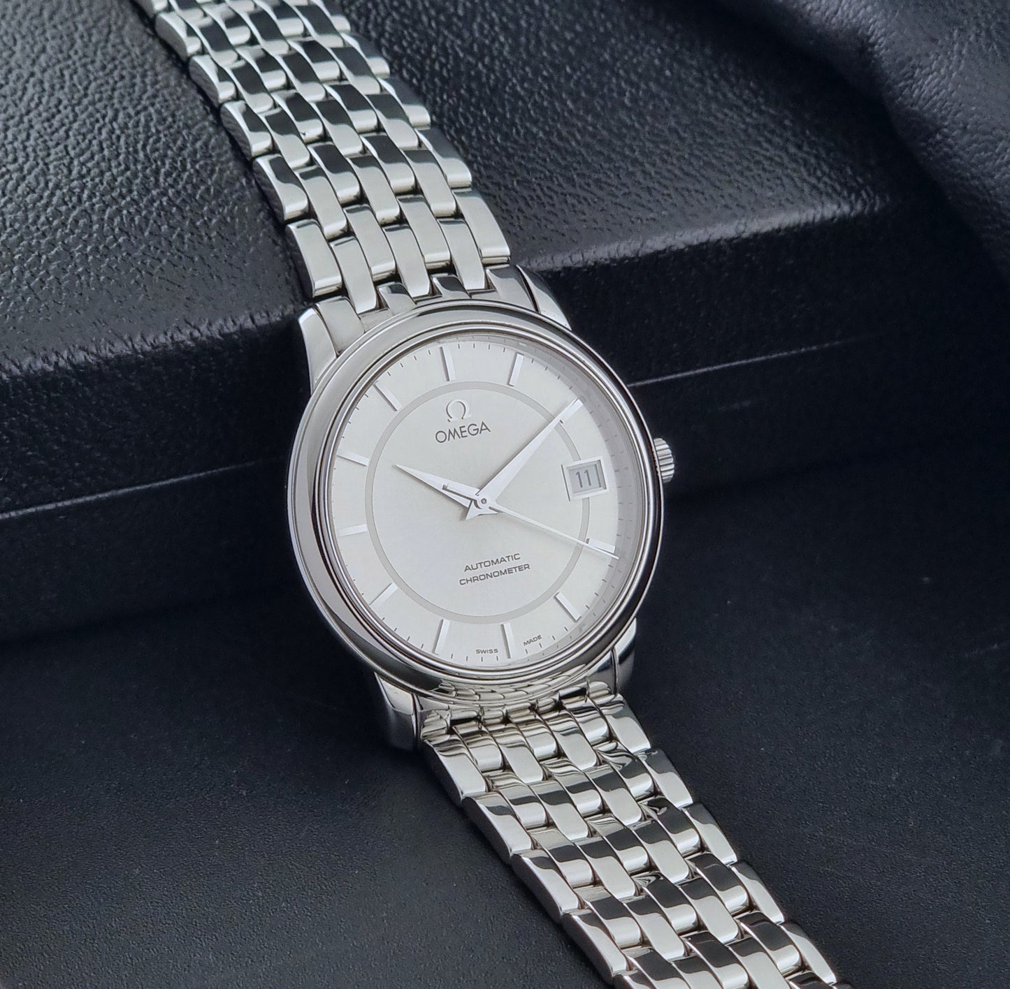 Omega watch a De-Ville Prestige 168.1050 with a stainless steel bracelet on a dark background side view