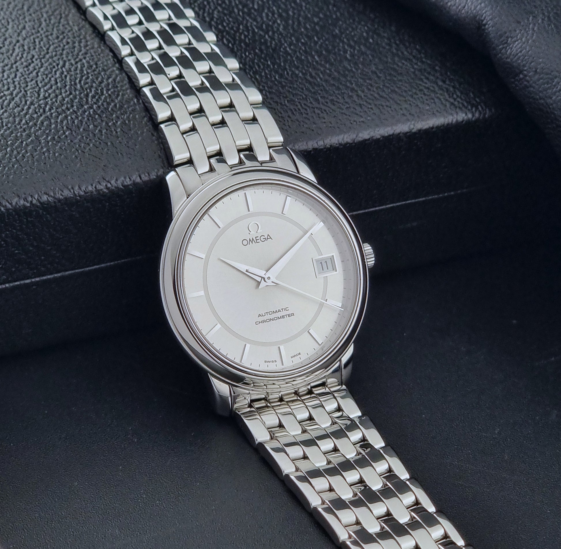 Omega watch a De-Ville Prestige 168.1050 with a stainless steel bracelet on a dark background side view