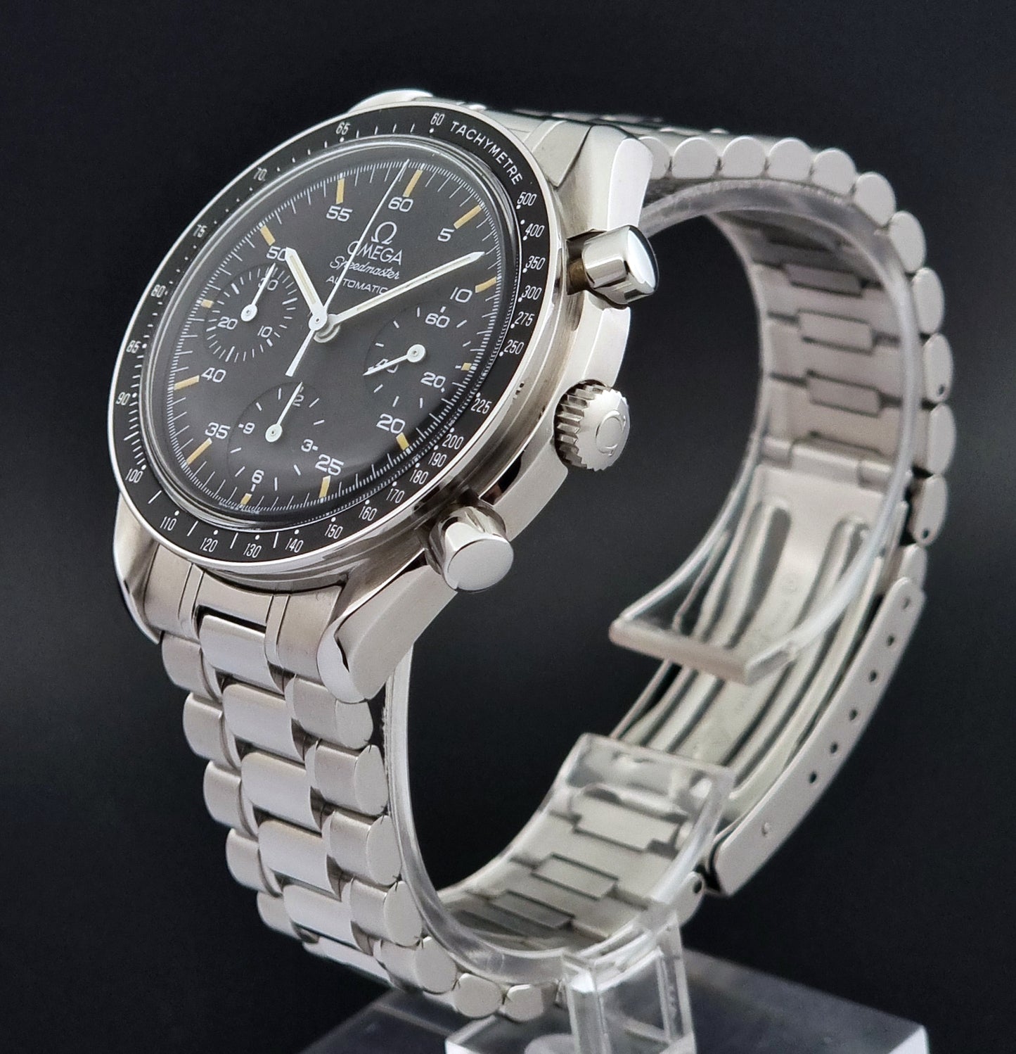 Vintage Omega watch Speedmaster Reduced 3510.50 watch with a black dial on a dark textured background close crown view