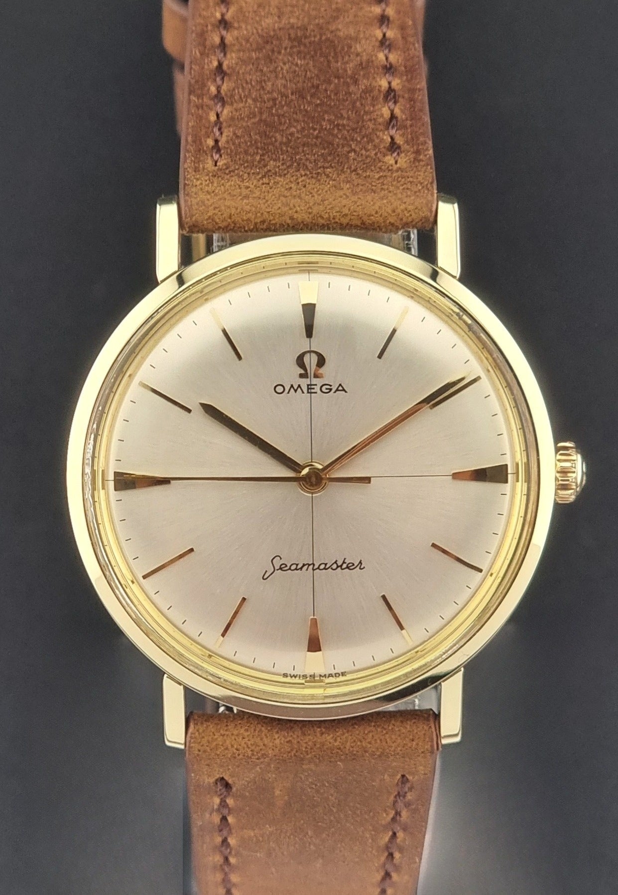 Vintage Omega Seamaster 14735 Gold watch with brown leather strap on a black background dial view