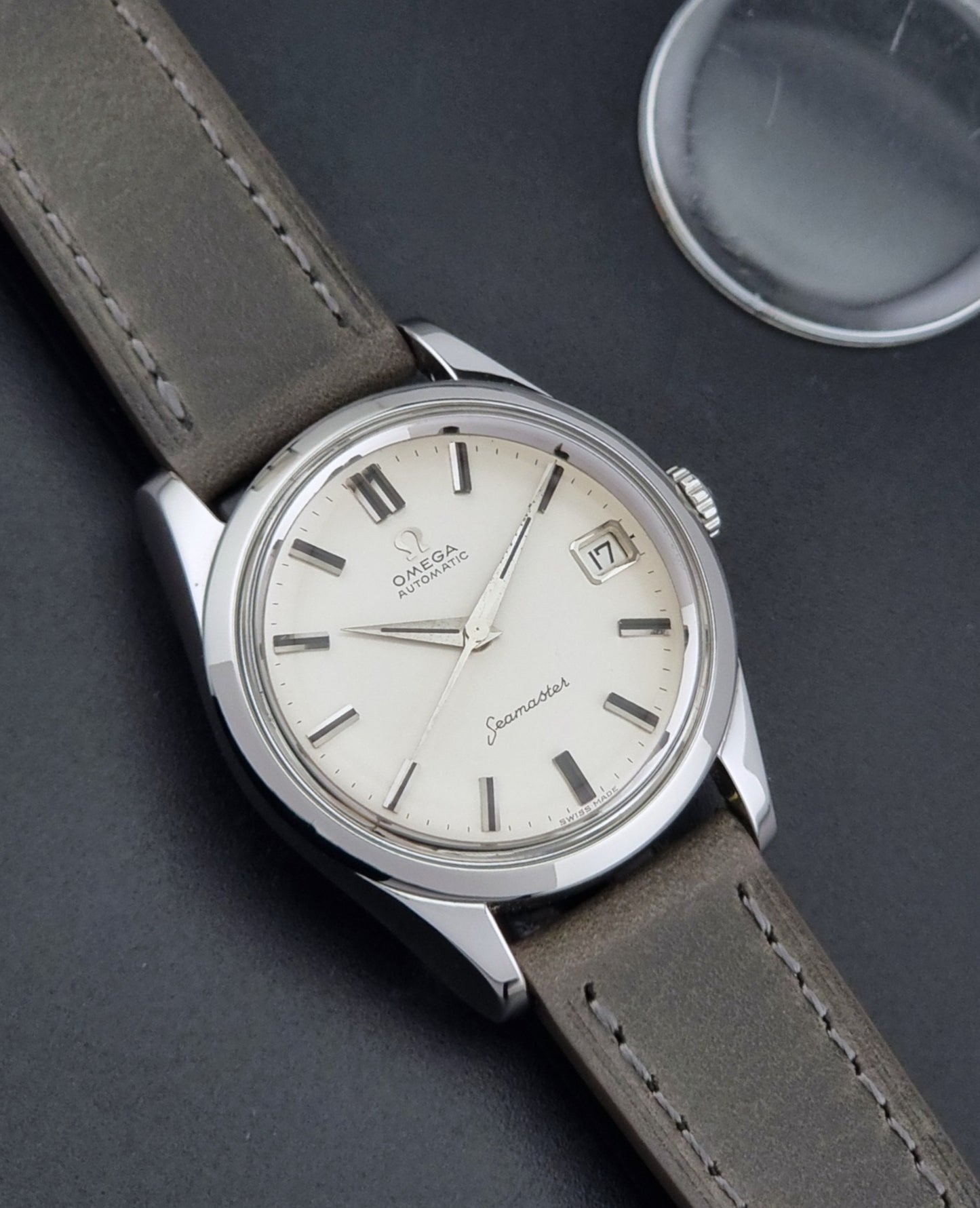 Vintage Omega Seamaster 14763 with a grey leather strap on a dark background front view