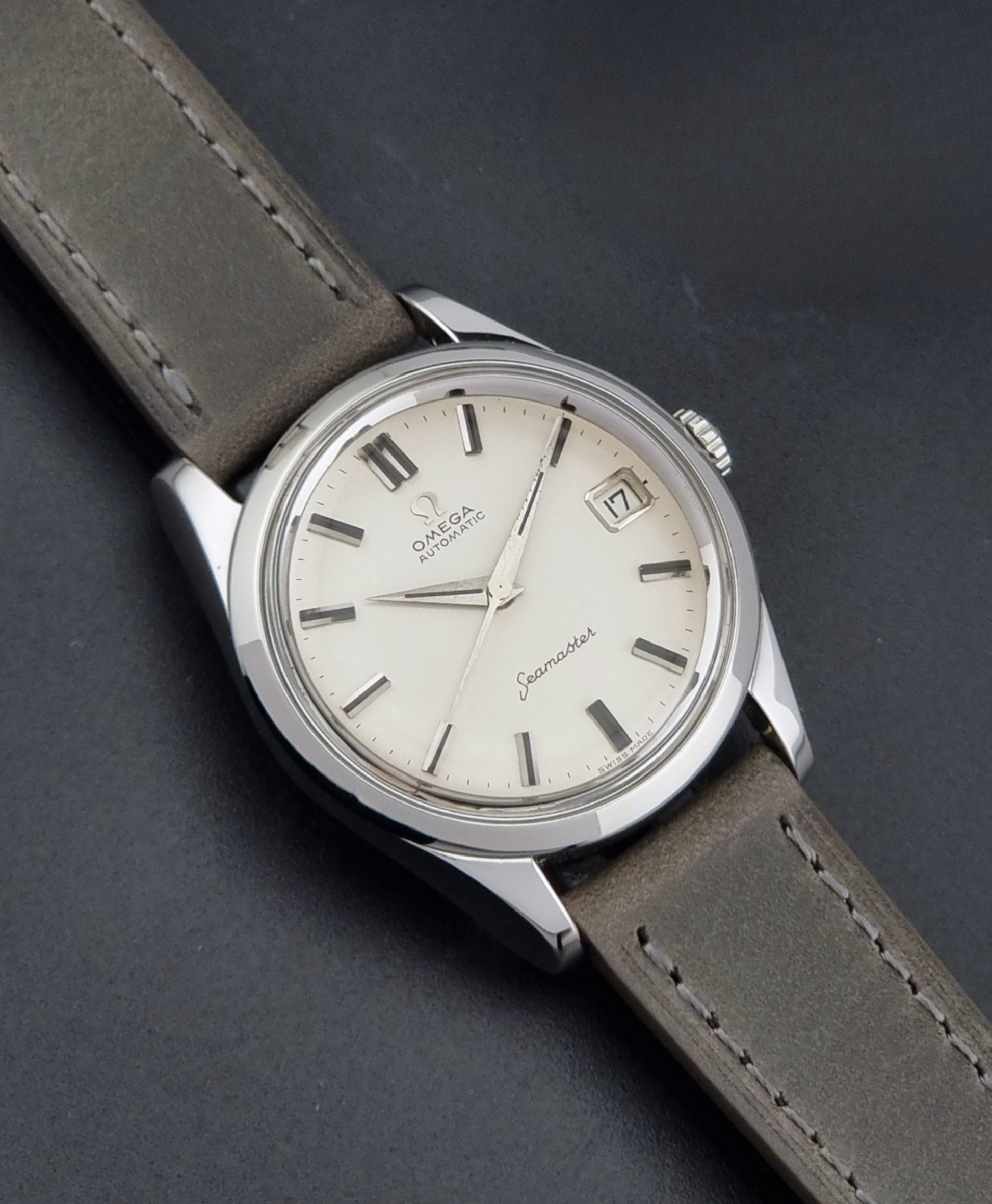 Vintage Omega Seamaster 14763 with a grey leather strap on a dark background close up dial view